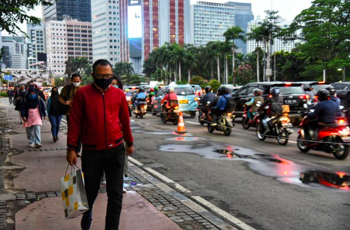 Beberapa Warga melintas di pedestrian kawasan Sudirman, Jakarta Pusat saat PSBB.