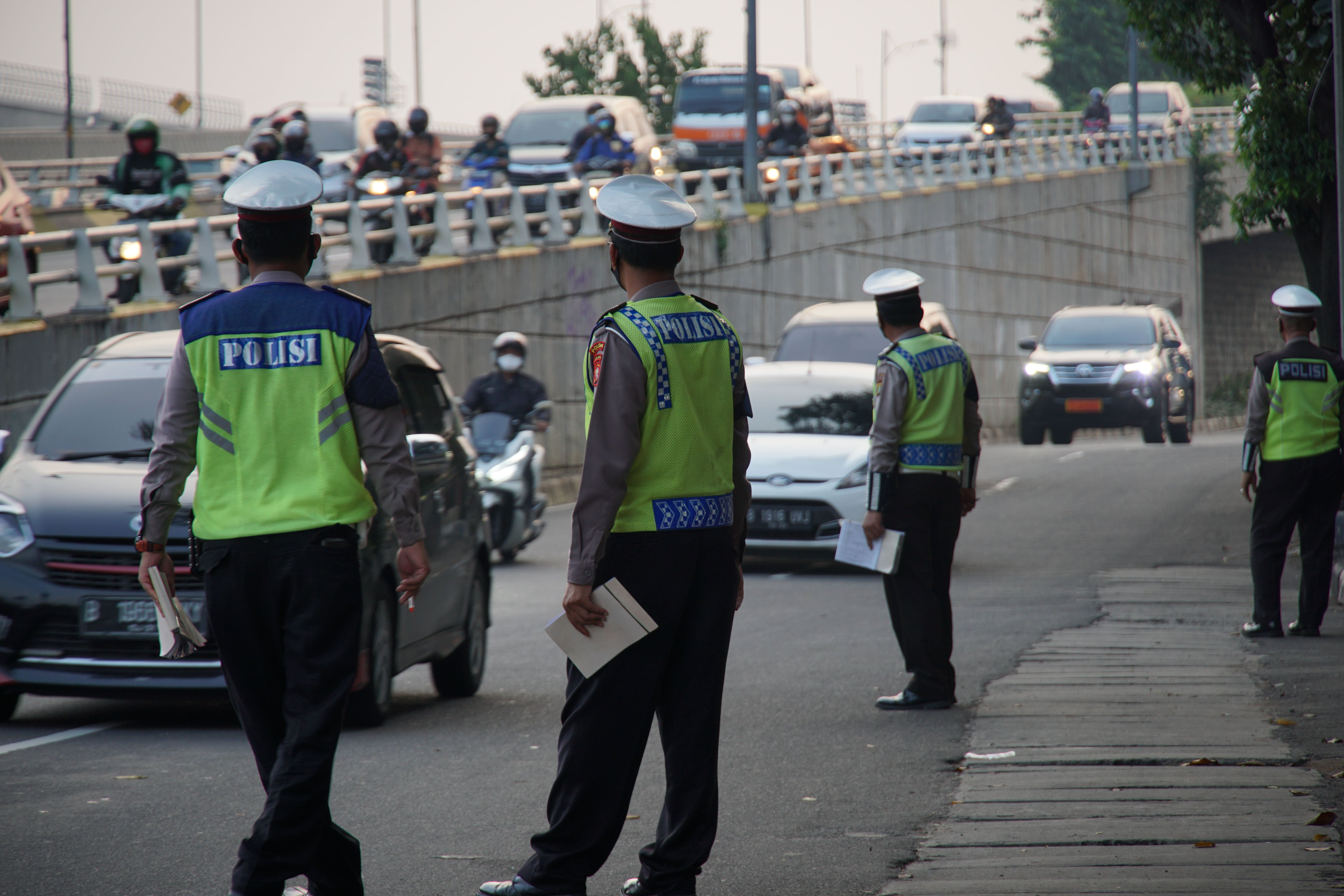 Polantas memantau kendaraan saat hari pertama pemberlakuan sanksi kebijakan ganjil-genap kendaraan di Jalan Letjen MT Haryono