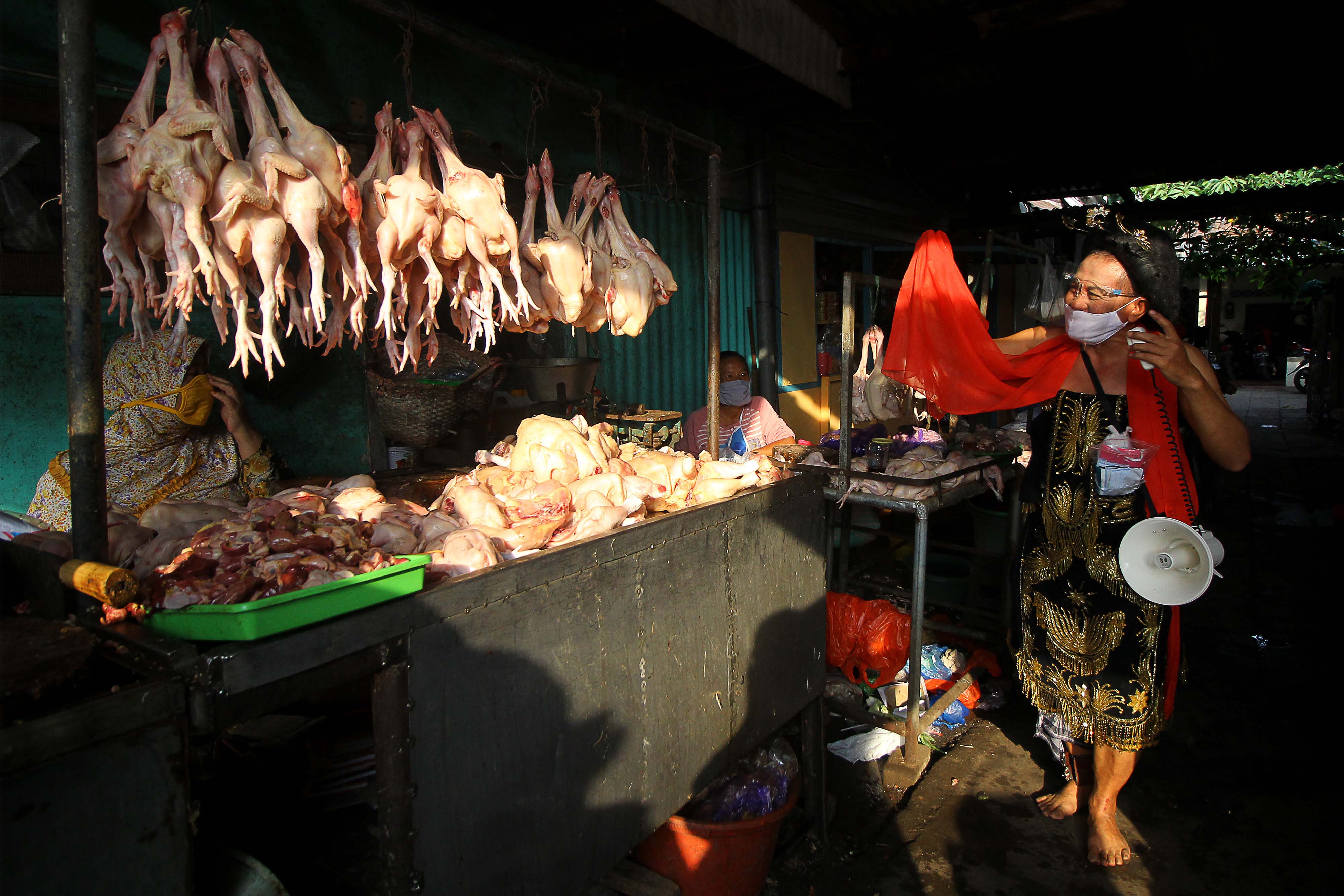 Seniman ludruk Meimura (kanan) mengenakan busana Tari Remo menyosialisasikan protokol kesehatan di Pasar Menur Surabaya, Rabu (5/8/2020).  
