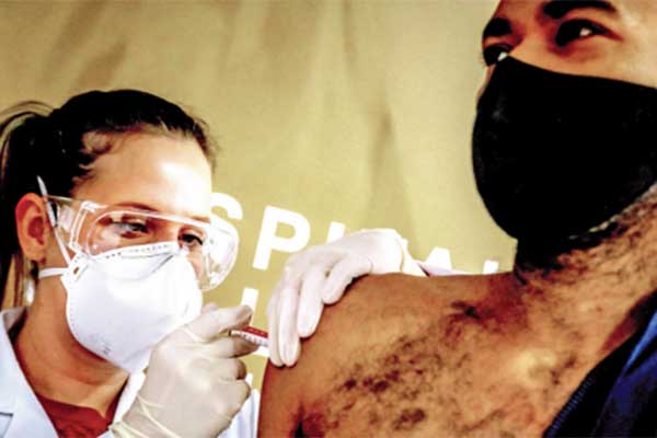 Petugas kesehatan dan relawan Paulo Roberto Oliveira menerima vaksin covid-19 yang diproduksi perusahaan Tiongkok Sinovac Biotech