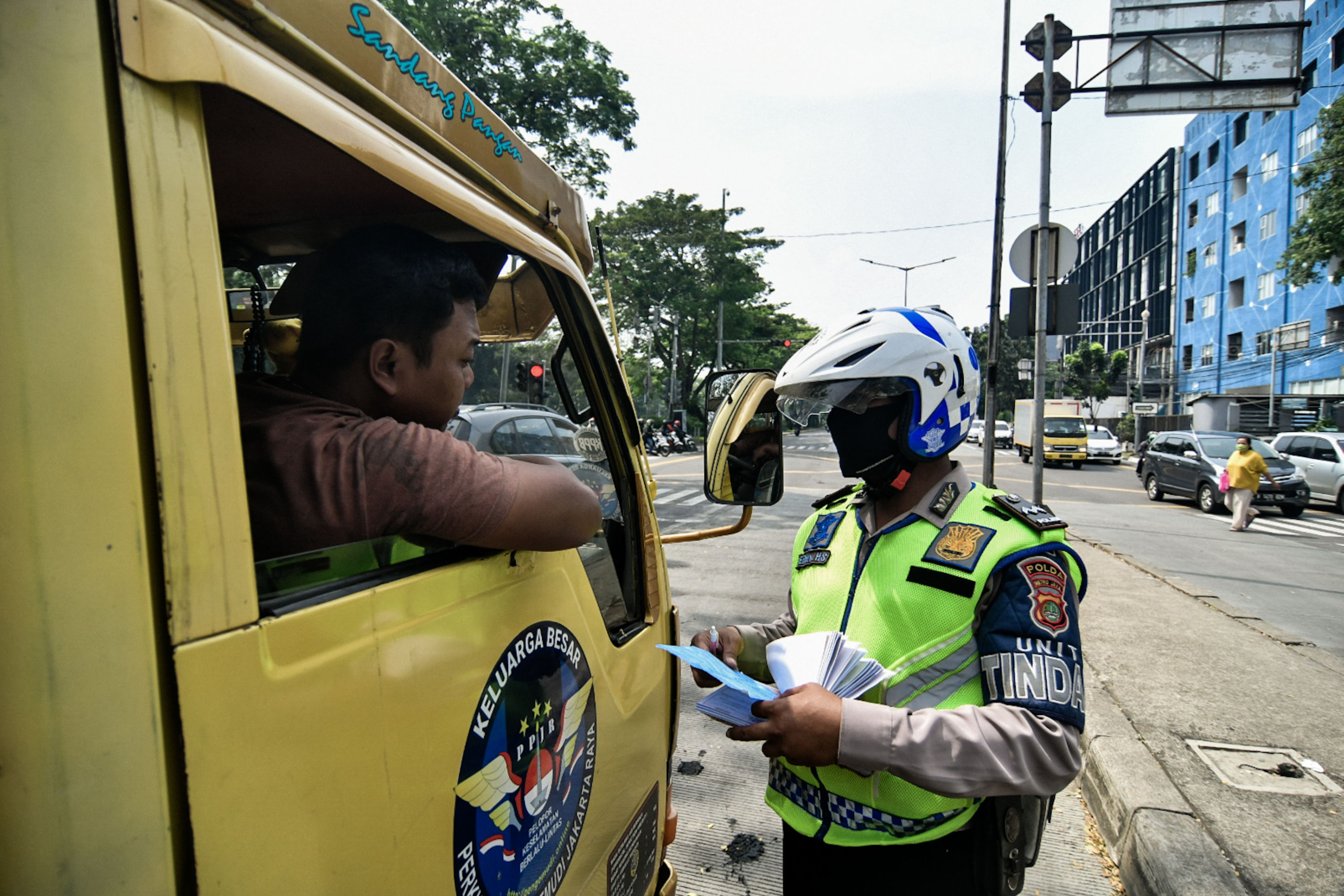Polisi Lalu lintas memberhentikan kendaraan yang menerobos jalur TransJakarta saat Operasi Patuh Jaya 2020
