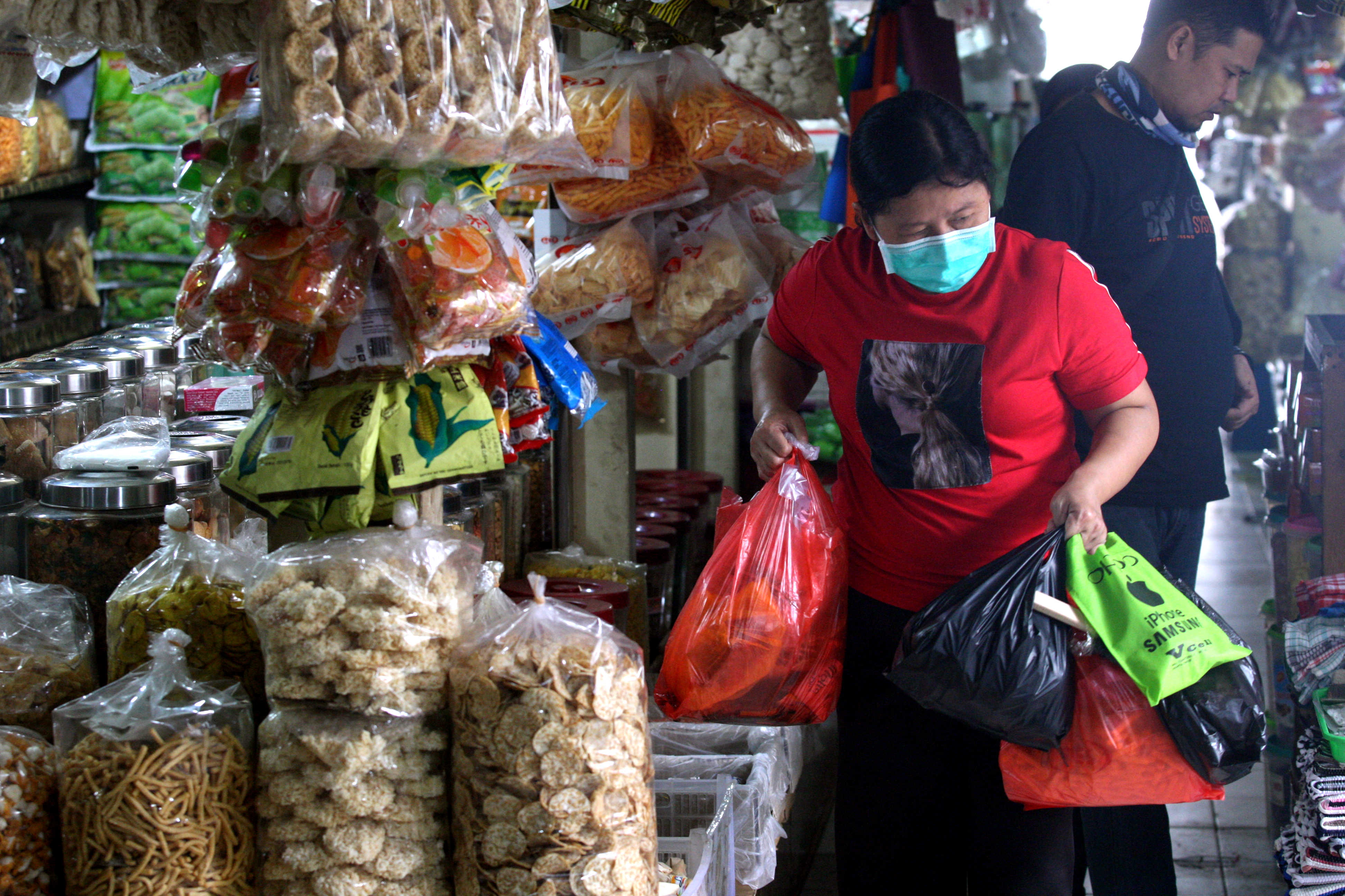 Warga berbelanja menggunakan kantong plastik sekali pakai di Pasar Cijantung, Jakarta (12/8/2020)