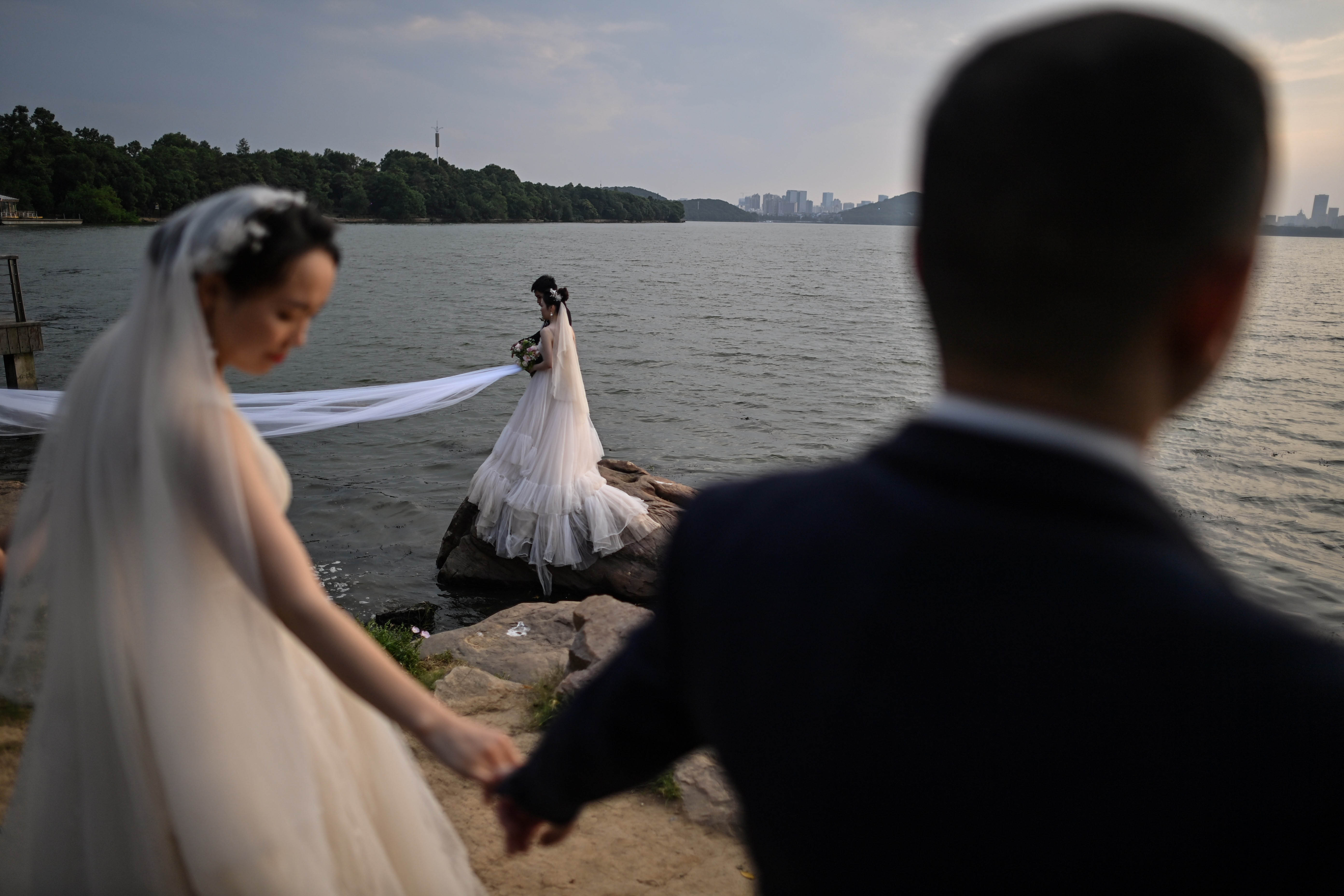 Pasangan pengantin melakukan sesi pemotretan di sebuah danau di Wuhan.