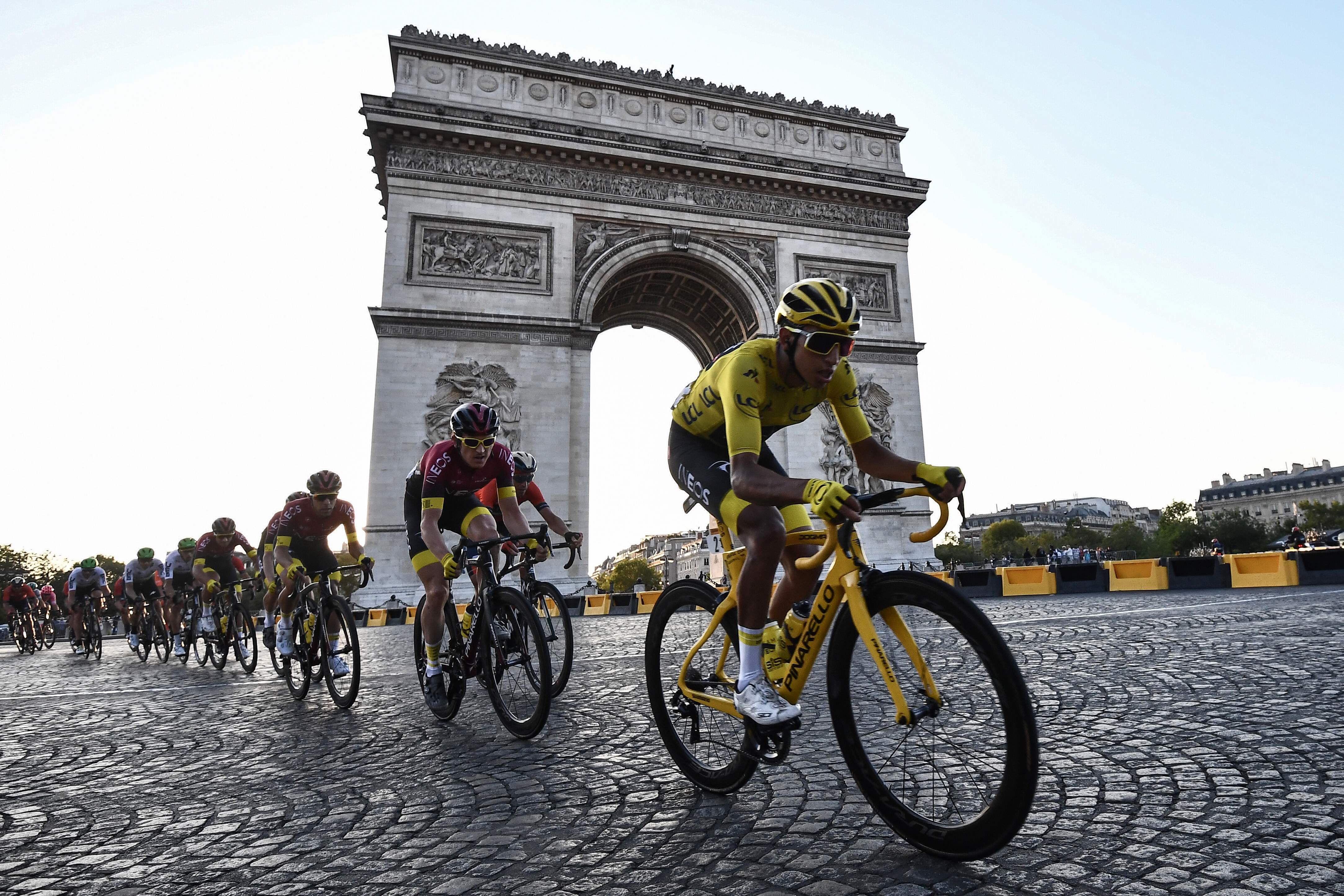Para pembalap melintas di dekat Arc de Triomphe, Paris saat perhelatan Tour de France 2019.