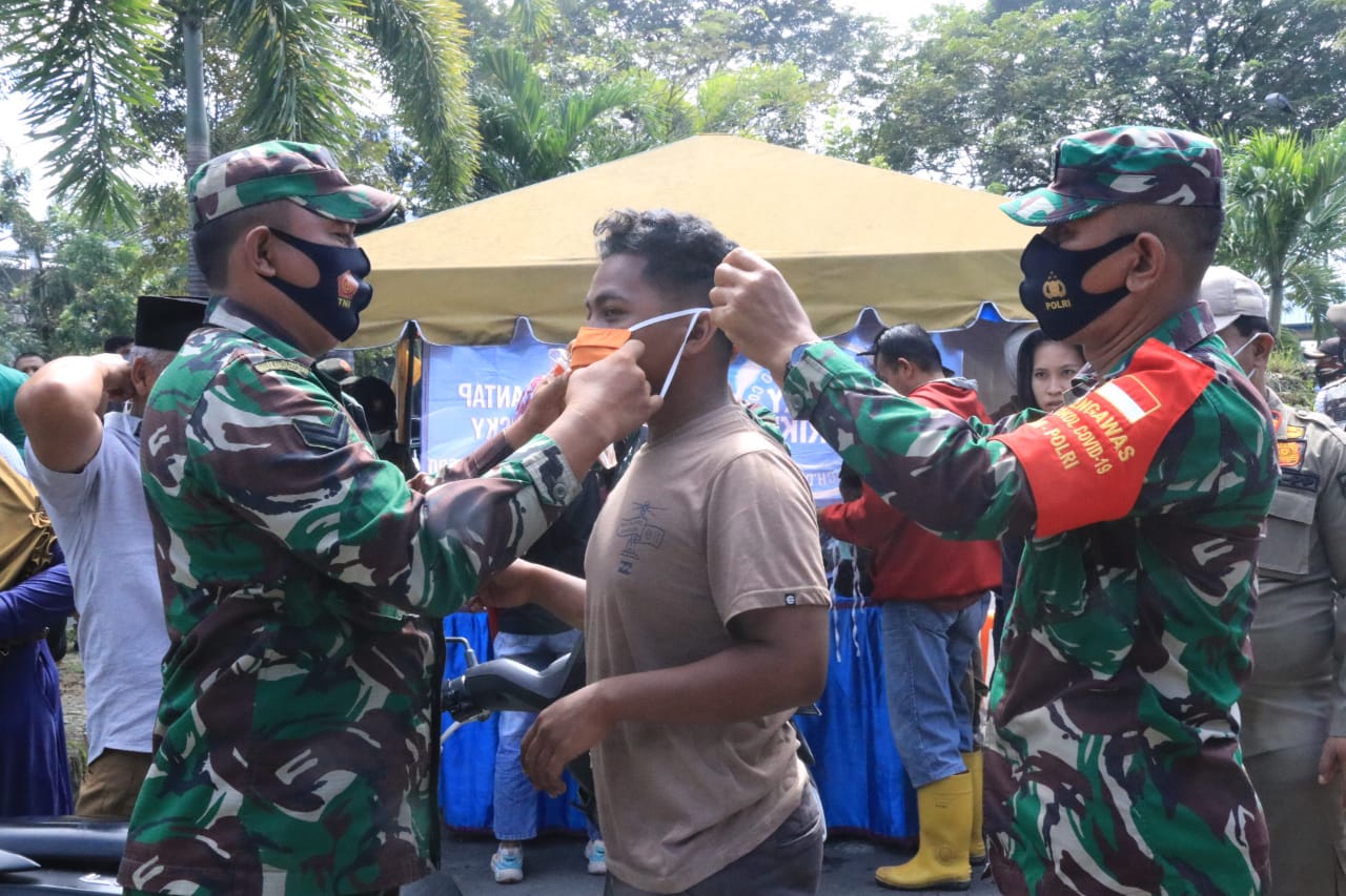 Dua personel TNI memakaikan masker kepada warga yang terjaring razia penegakan protokol kesehatan pencegahan Covid-19 di Kota Medan, kemarin