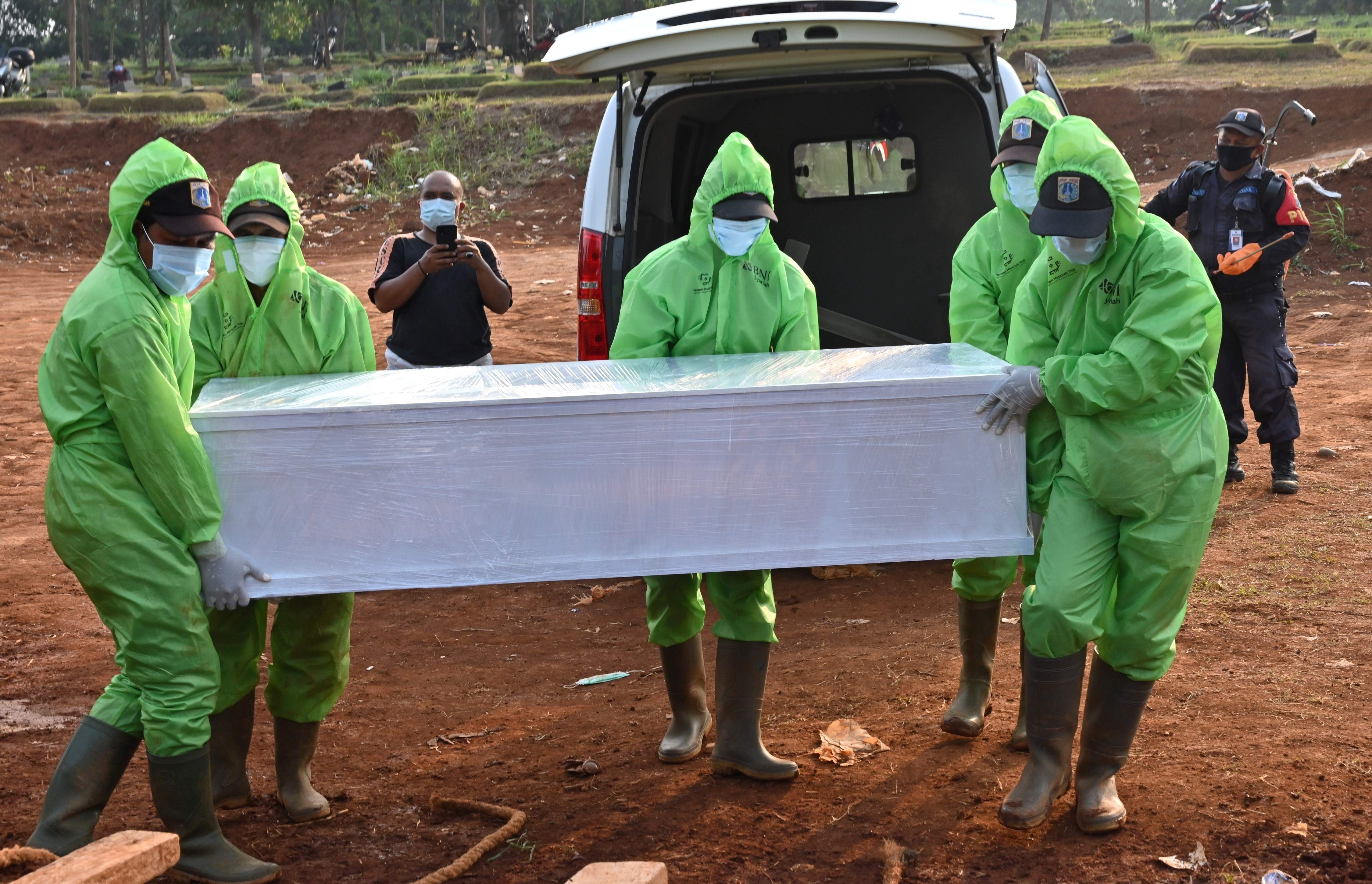 Petugas memakamkan jenazah pasien covid-19 di TPU Pondok Ranggon, Jakarta.