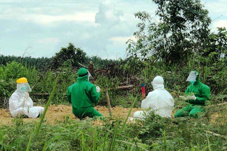 Kapolres Tanjab Barat AKBP Guntur Saputro (APD hijau dua dari kiri), Minggu (30/8), memanjatkan doa seusai memakamkan jenazah MR, 35.