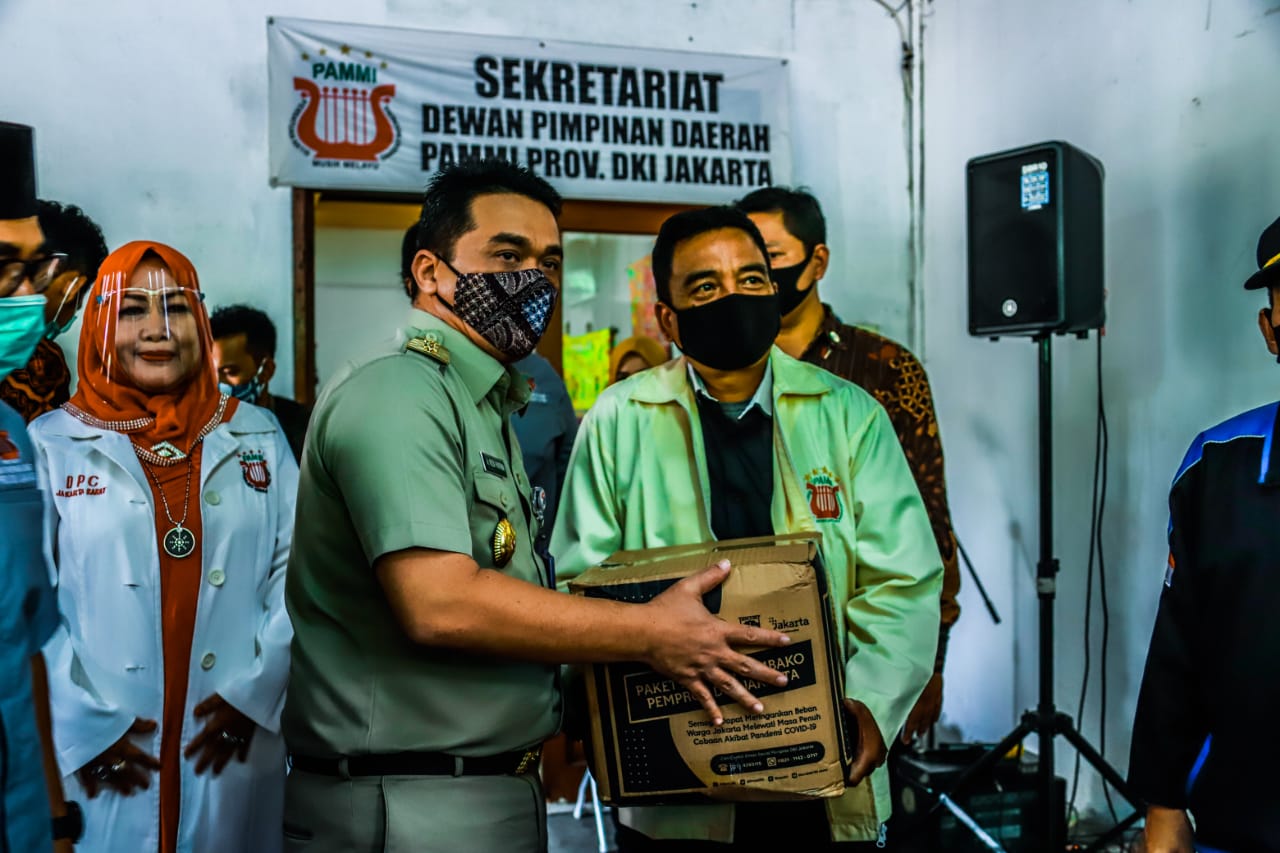 Wakil Gubernur DKI Jakarta, Ahmad Riza Patria (kiri) saat menyerahkan bantuan.