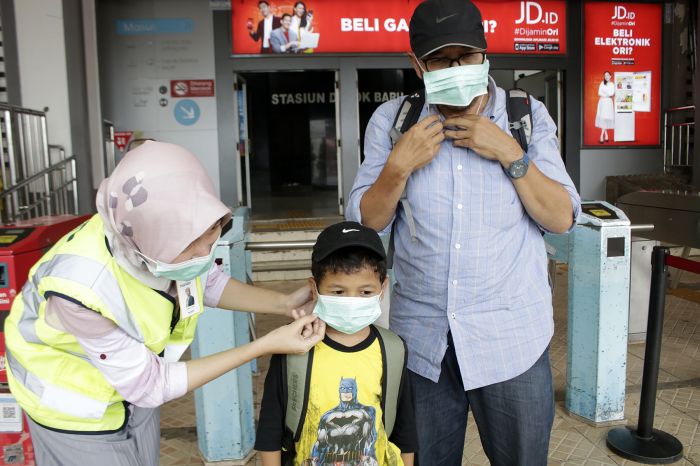 Pembagian masker gratis kepada warga di Stasiun Depok Baru, Depok, Jawa Barat.