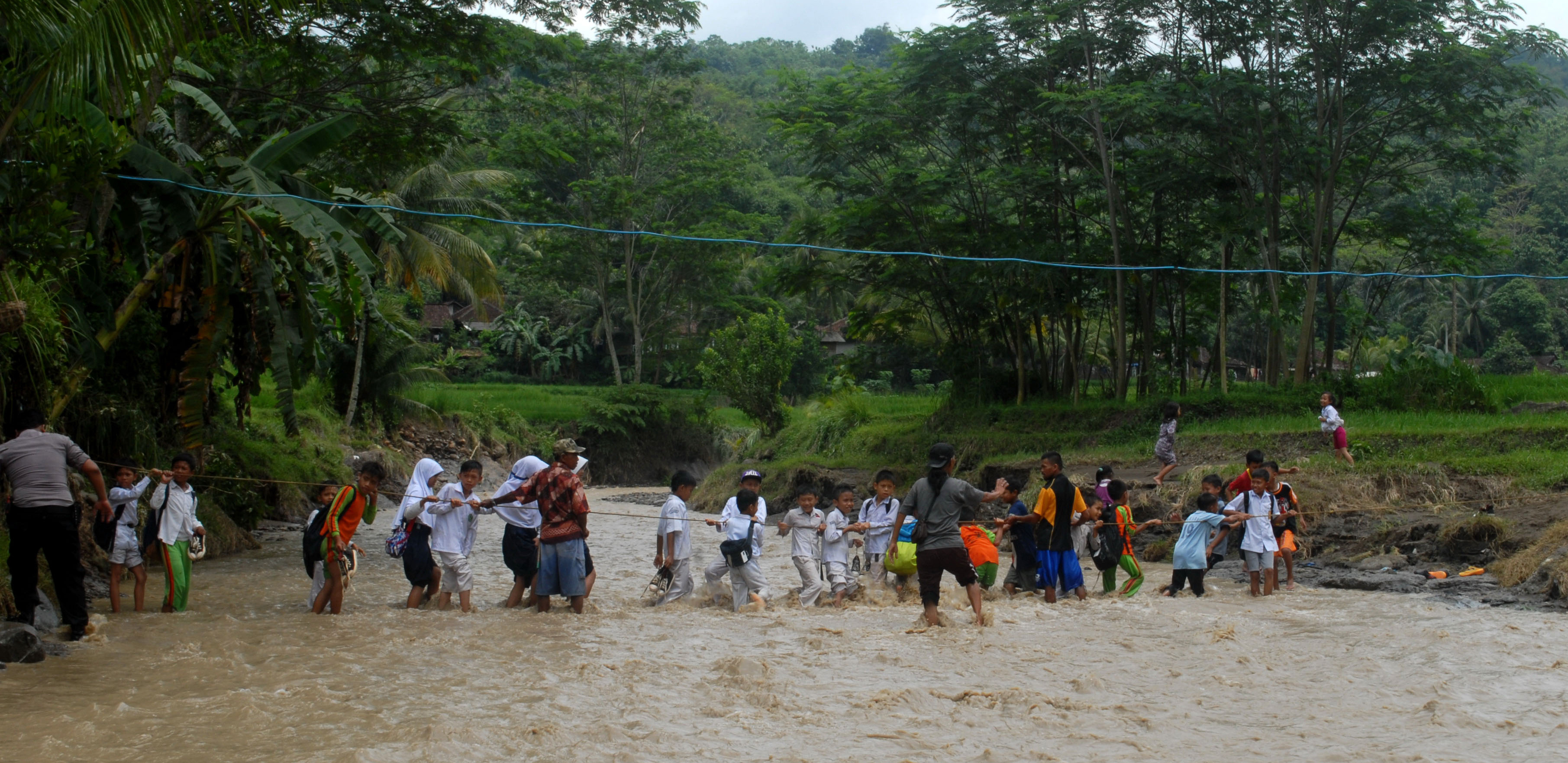 Pelajar menyeberang sungai Cisarua usai pulang dari sekolah di Desa Bantarkalong, Kecamatan Warungkiara, Sukabumi, Jawa Barat.
