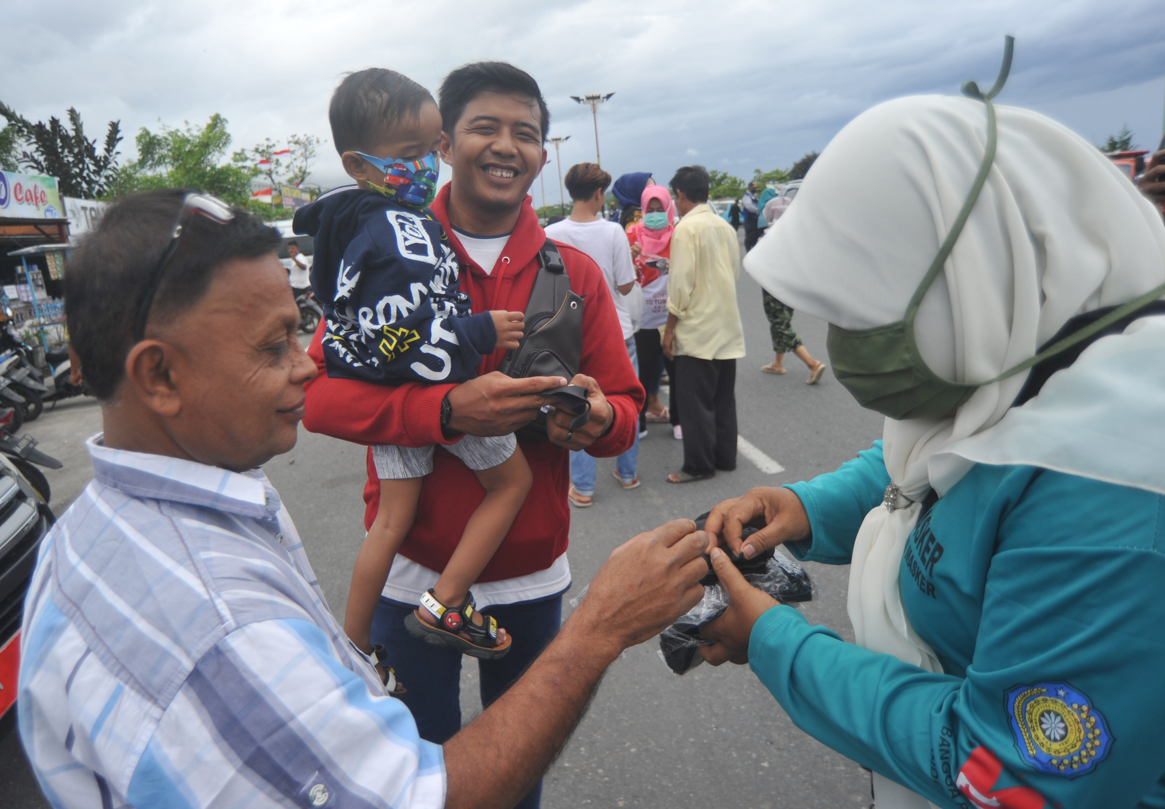 Petugas membagikan masker kepada warga, di Pantai Padang, Sumatera Barat, pekan lalu.
