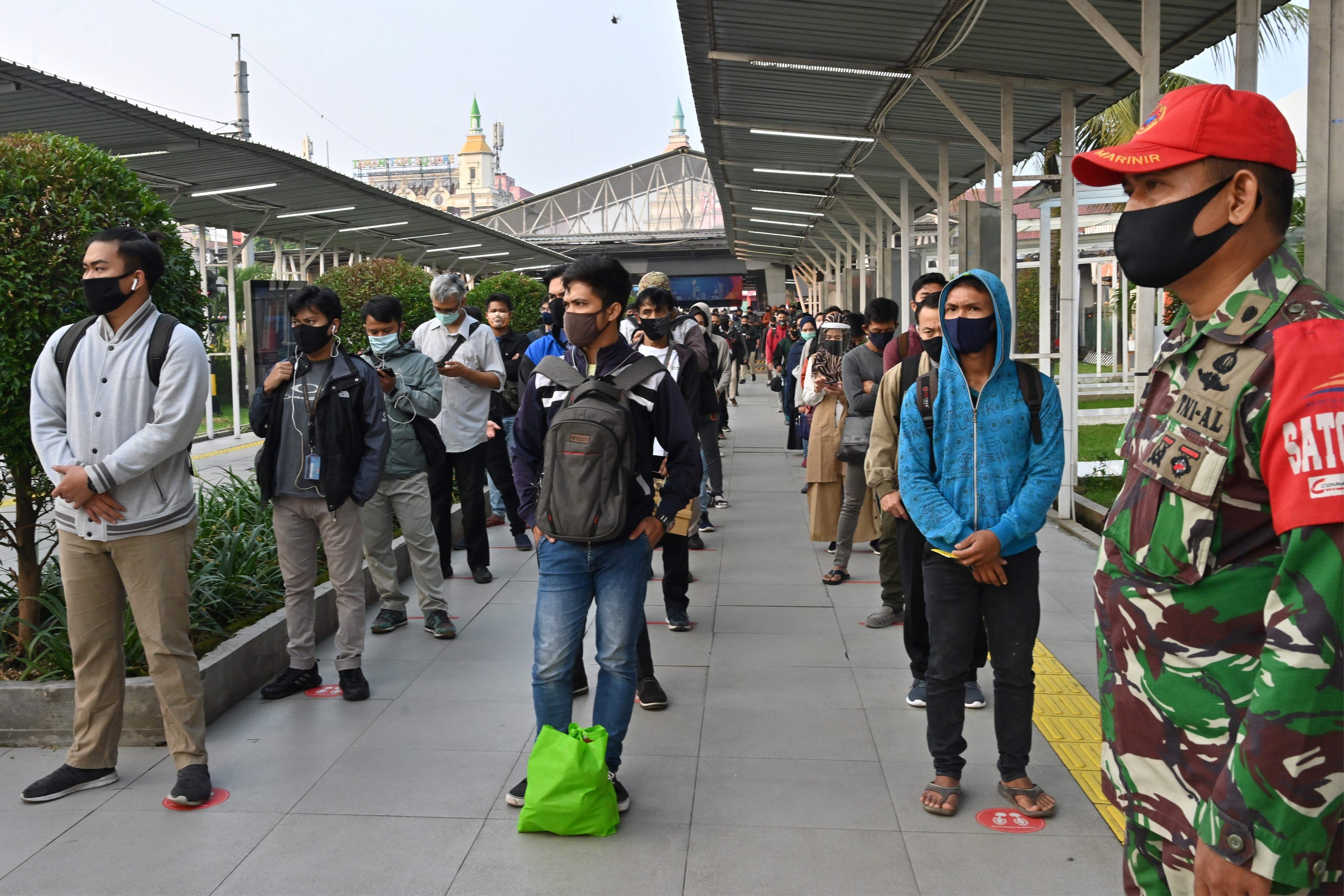 Masyarakat berjajar mengantre di stasiun Bogor dengan penerapan jaga jarak