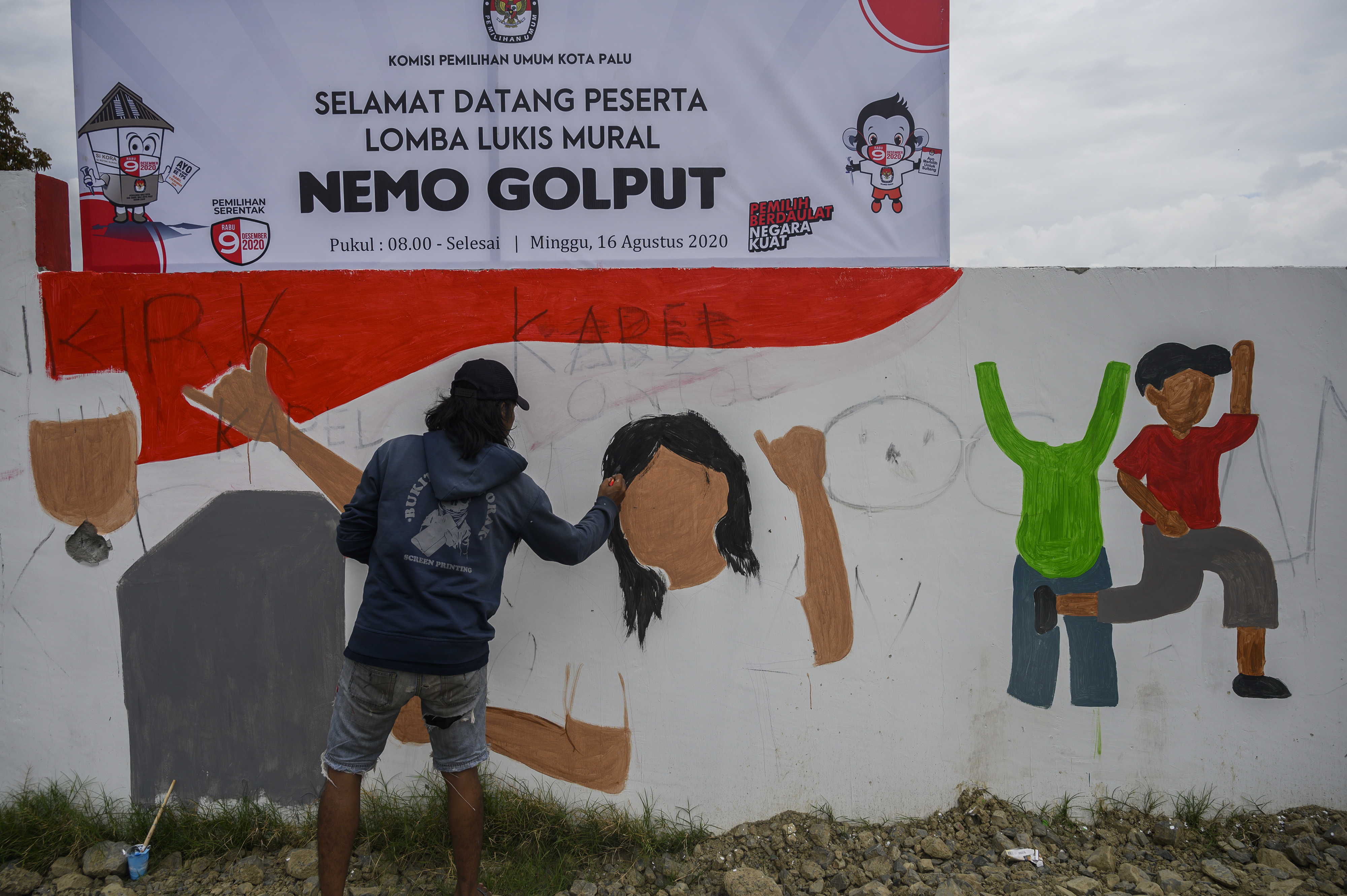 Seorang peserta menyelesaikan lukisannya pada lomba mural bertema Nemo Golput (Jangan Golput) di Palu, Sulawesi Tengah.