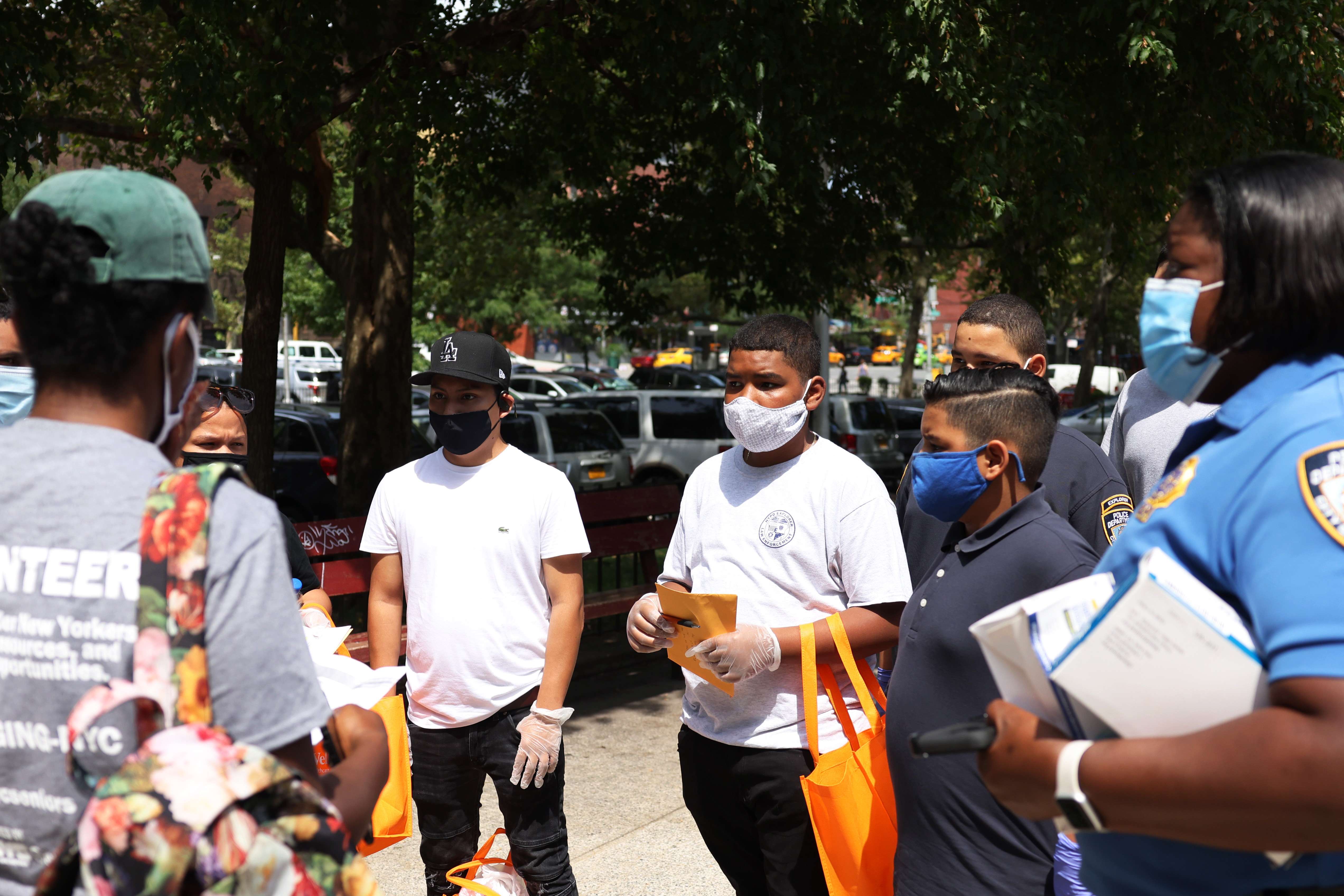 Anggota NYPD Law Enforcement Explorers mendapatkan instruksi menit terakhir sebelum mengirim makanan pada 14 Agustus 2020 di New York City.