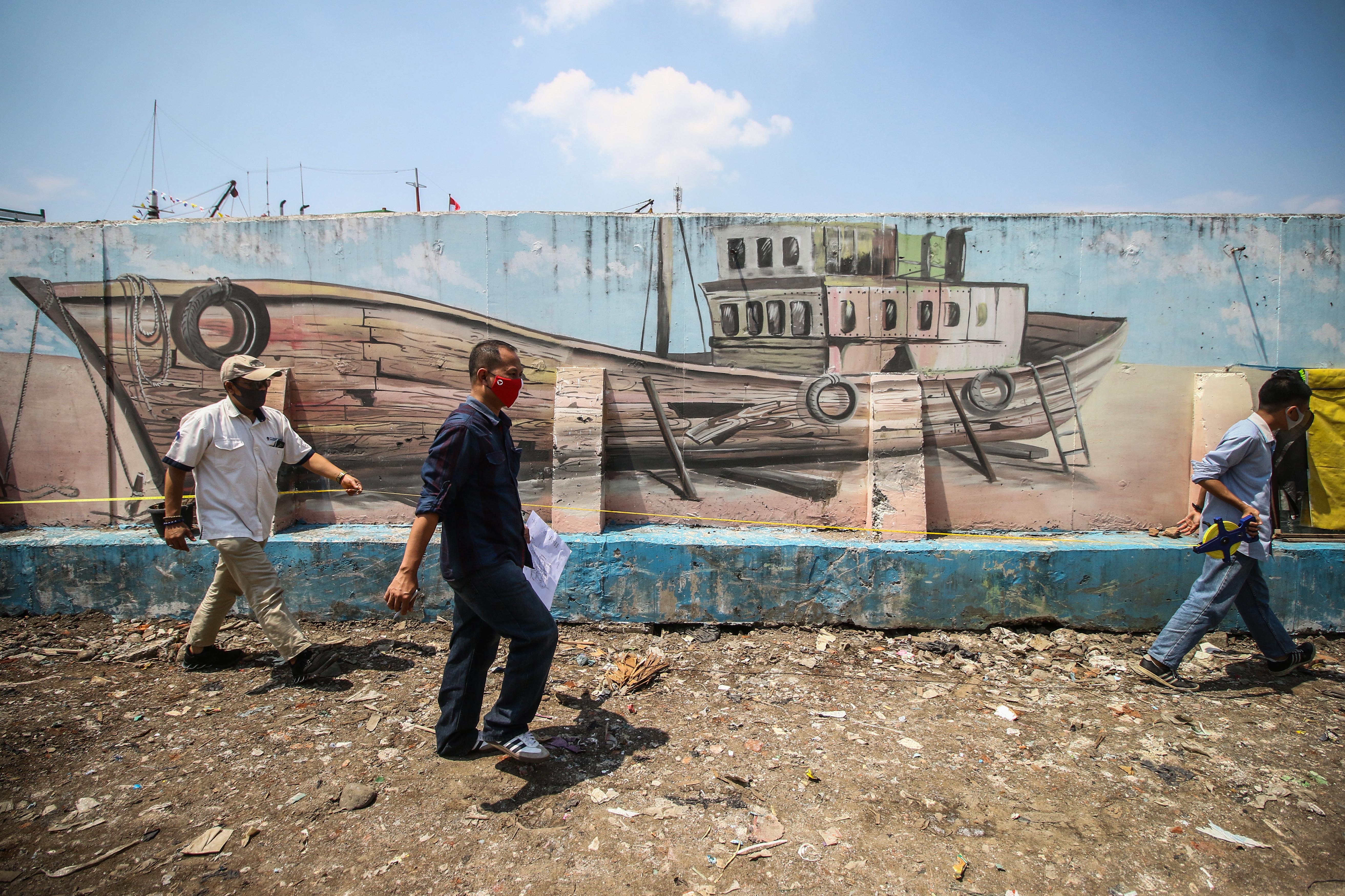  Petugas melakukan pengukuran lokasi di Kampung Akuarium, Jakarta, Rabu (19/8/2020). 