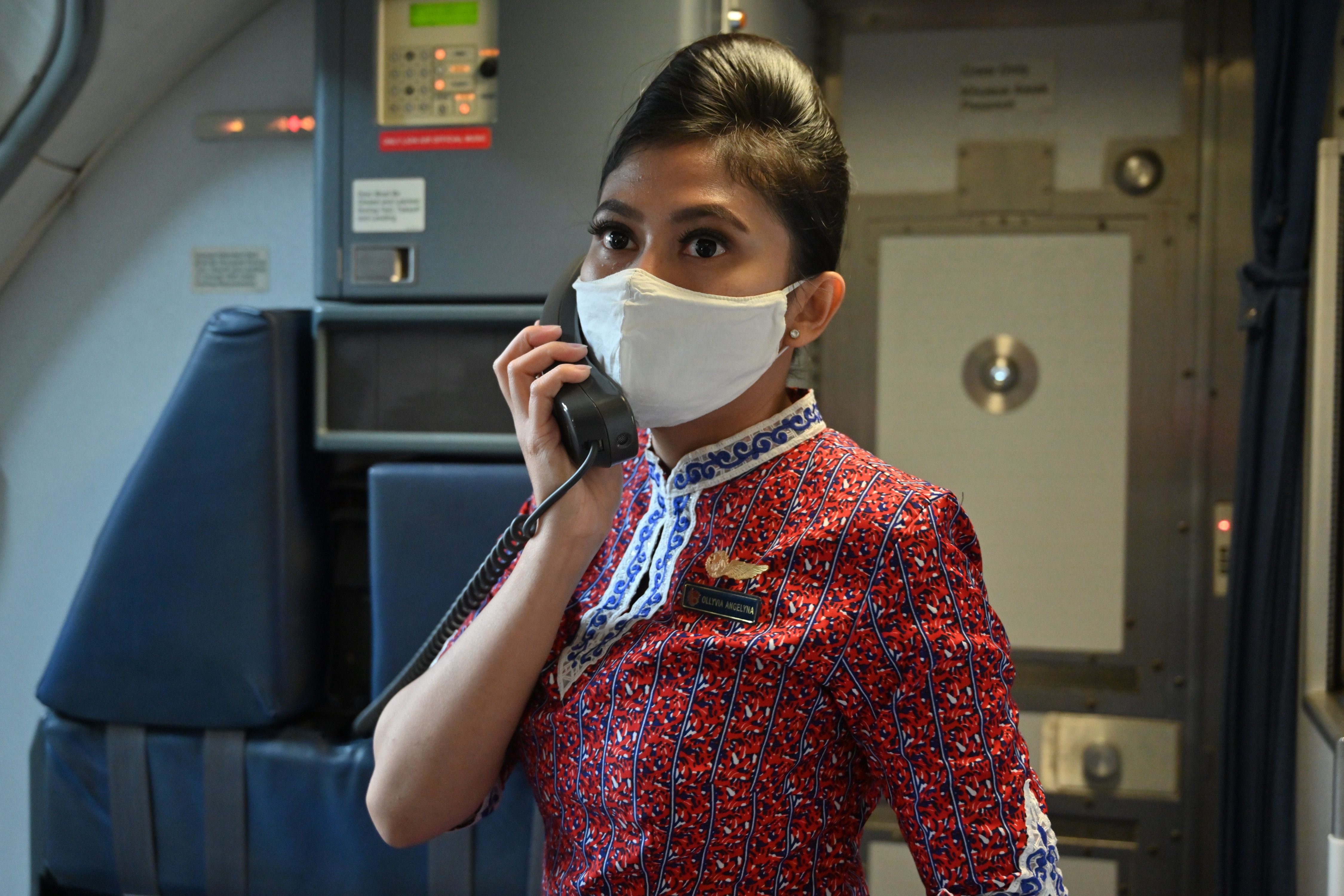 Pramugari maskapai Lion Air menggunakan masker sebagai pencegahan penyebaran covid-19.