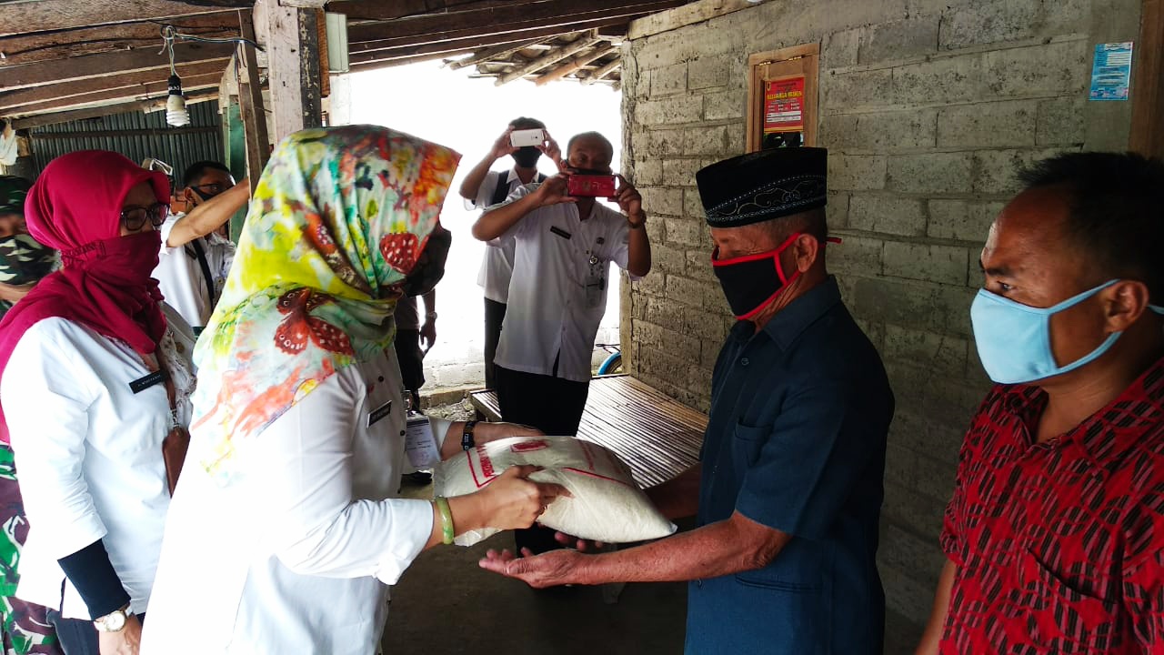 Bupati Sri Mulyani menyerahkan bantuan beras kepada warga terdampak banjir di Desa Burikan.