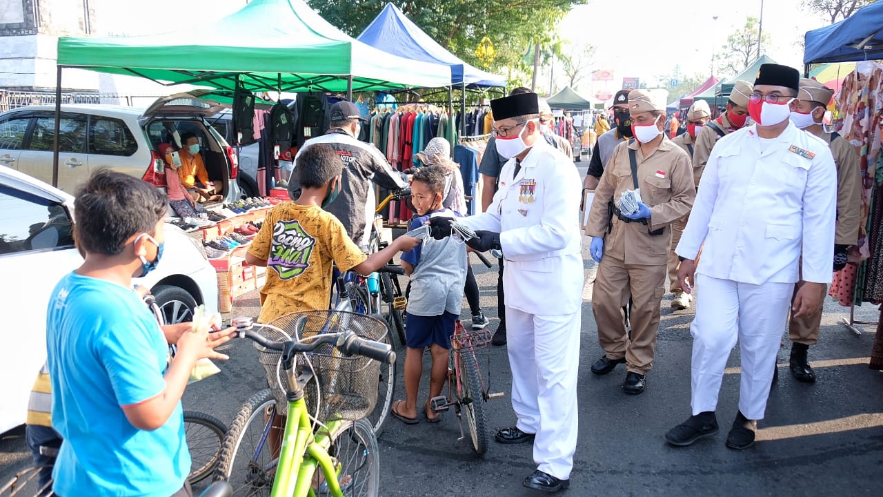 Kapolresta Sidoarjo Kombes Sumardji membagi-bagikwn masker ke warga. 