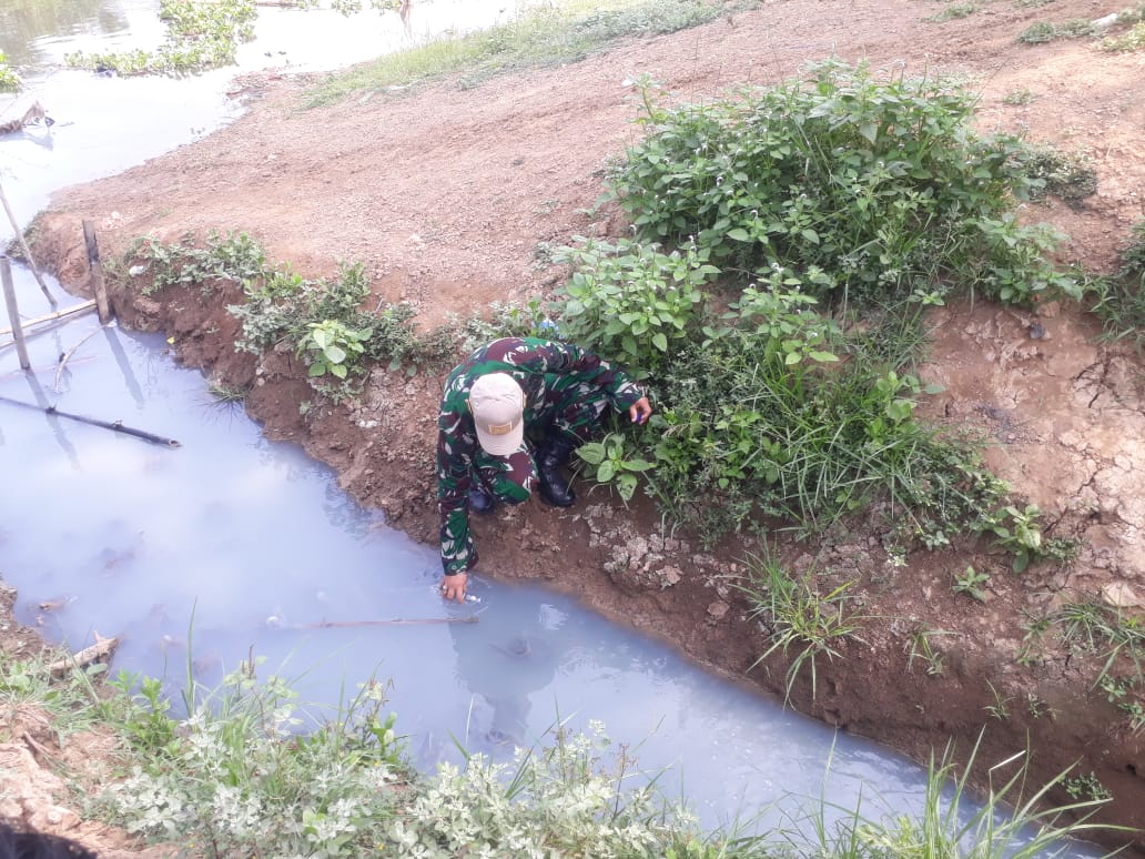 Petugas Sektor 19 Satgas Citarum Karawang Tengah Mengambil Sampel Air dari Gorong-Gorong yang Mengalir ke Sungai Citarum