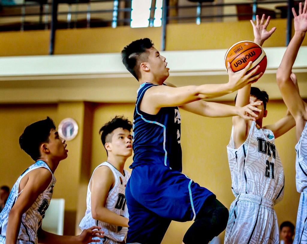 Aksi pemain basket asal Bandung, Indonesia, Claudius Teo (tengah) dalam sebuah ajang pertandingan basket. 