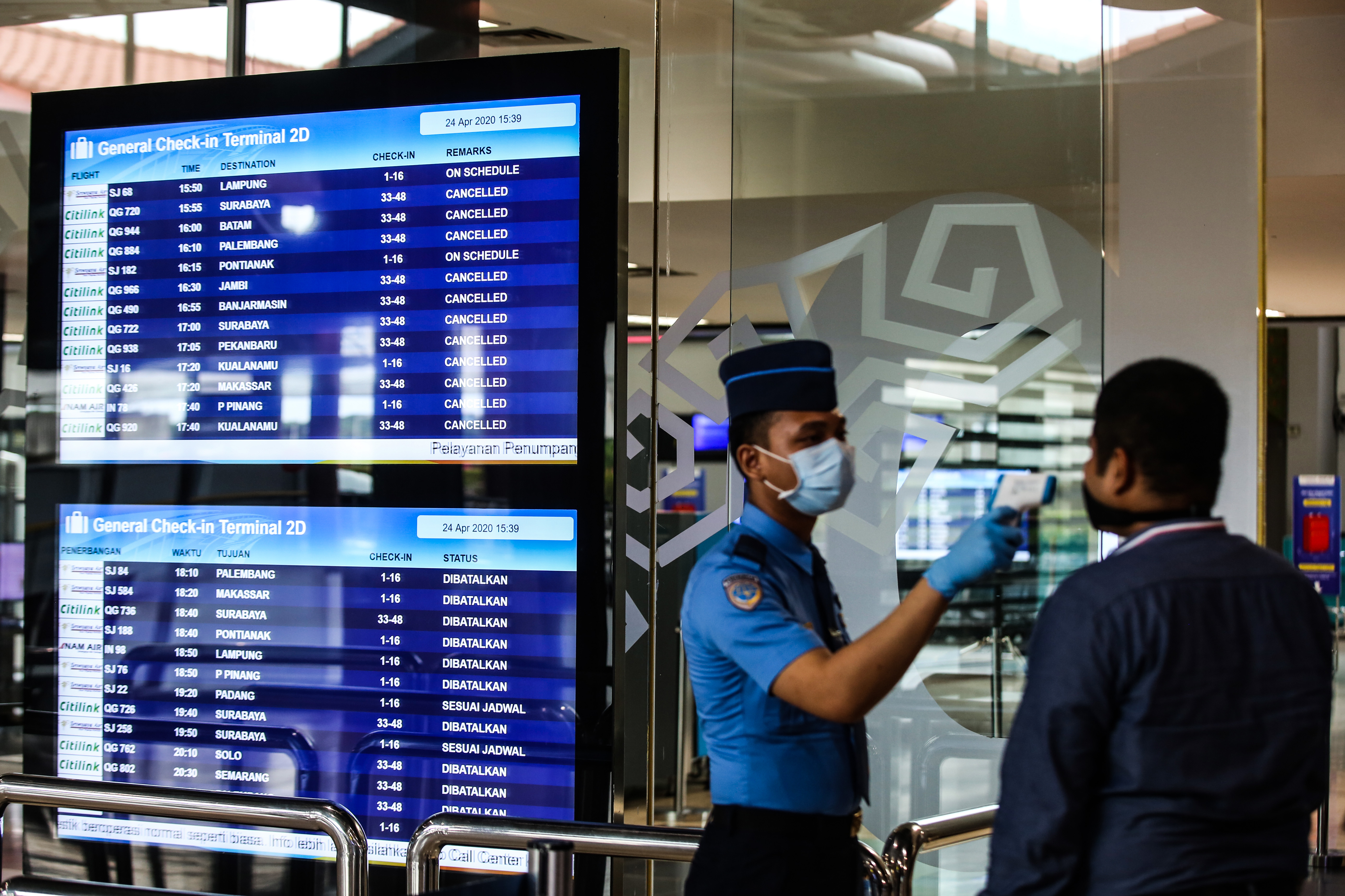 Petugas melakukan pengecekan suhu tubuh kepada calon penumpang di Terminal 2 Bandara Soekarno Hatta, Tangerang, Banten, Jumat (24/4/2020)