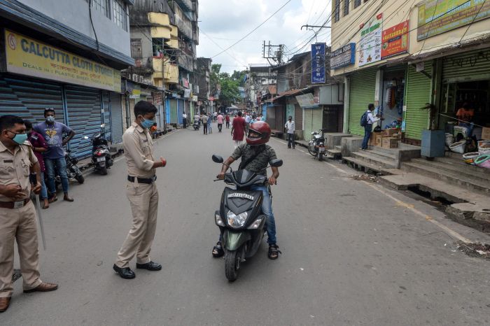 P Polisi menghentikan pengendara sepeda motor yang hendak masuk pasar yang ditutup karena lockdown lagi di Siliguri, India, Kamsi (16/7). 