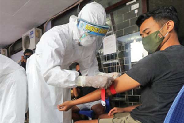  Tenaga medis mengambil sampel darah pesepak bola Persik Kediri Jeff erson Alves Olivira (kiri) dan ofisial tim Persik Kediri