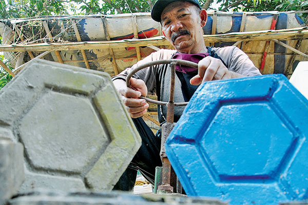 Petugas membuat paving block dari limbah sampah plastik di Tempat Pengelolaan Sampah Terpadu (TPST)  