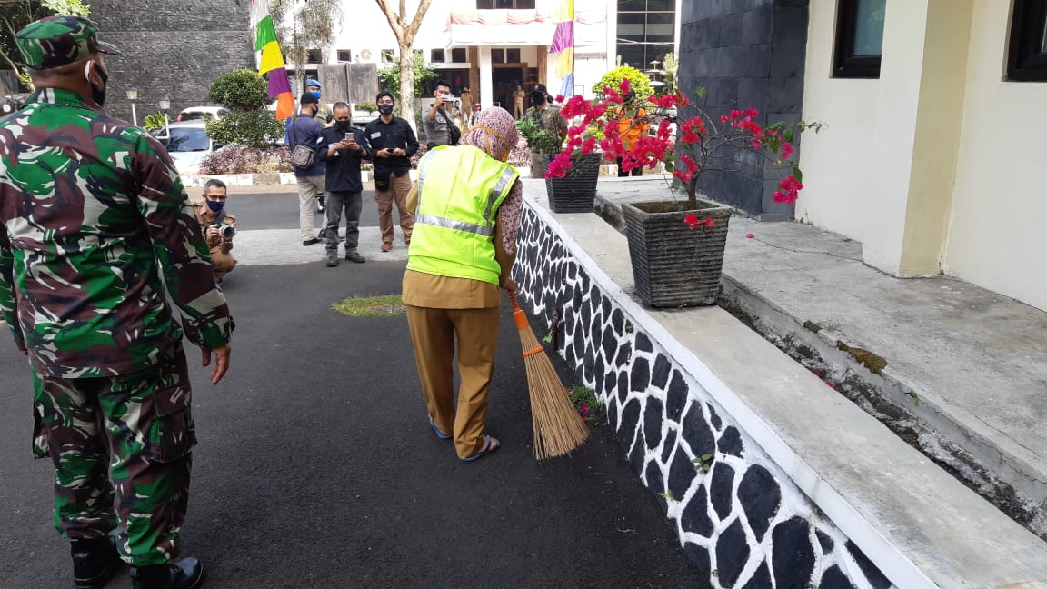 PNS di Kantor Wali Kota Tasikmalaya, Jaw Barat yang tidak mengeanakan masker dihukum membersihkan halaman kantor.