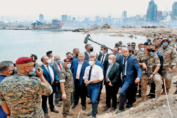 Presiden Prancis Emmanuel Macron (berkemeja putih) melihat lokasi terjadinya ledakan dahsyat di kawasan pelabuhan Kota Beirut, Libanon