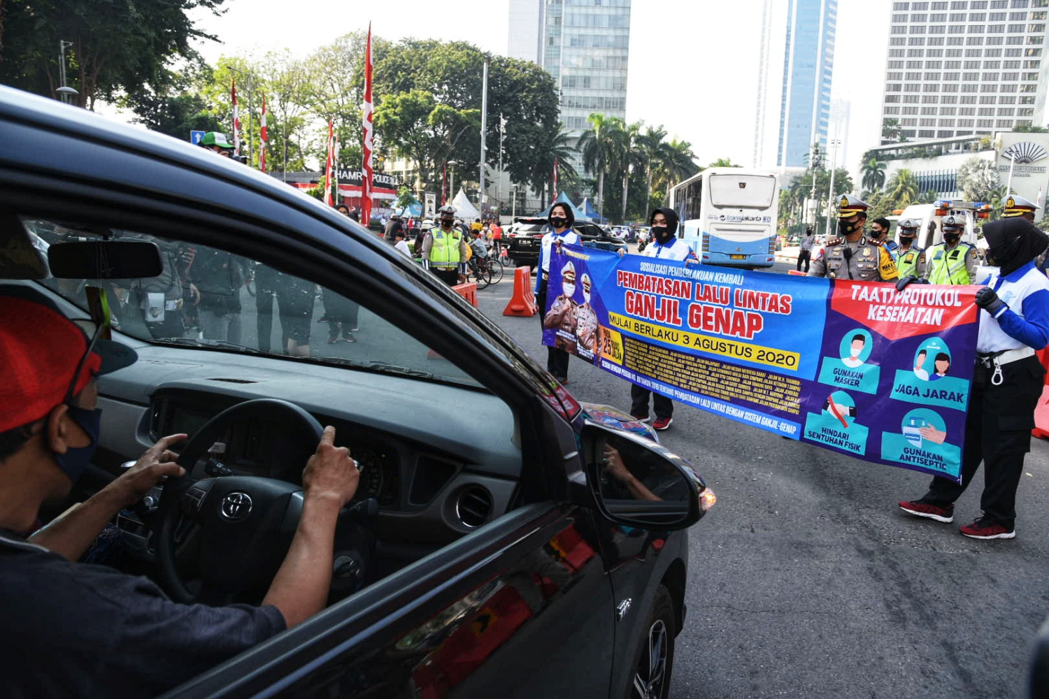 Polisi melakukan sosialisasi kebijakan ganjil genap di kawasan Bundaran HI, Jakarta.
