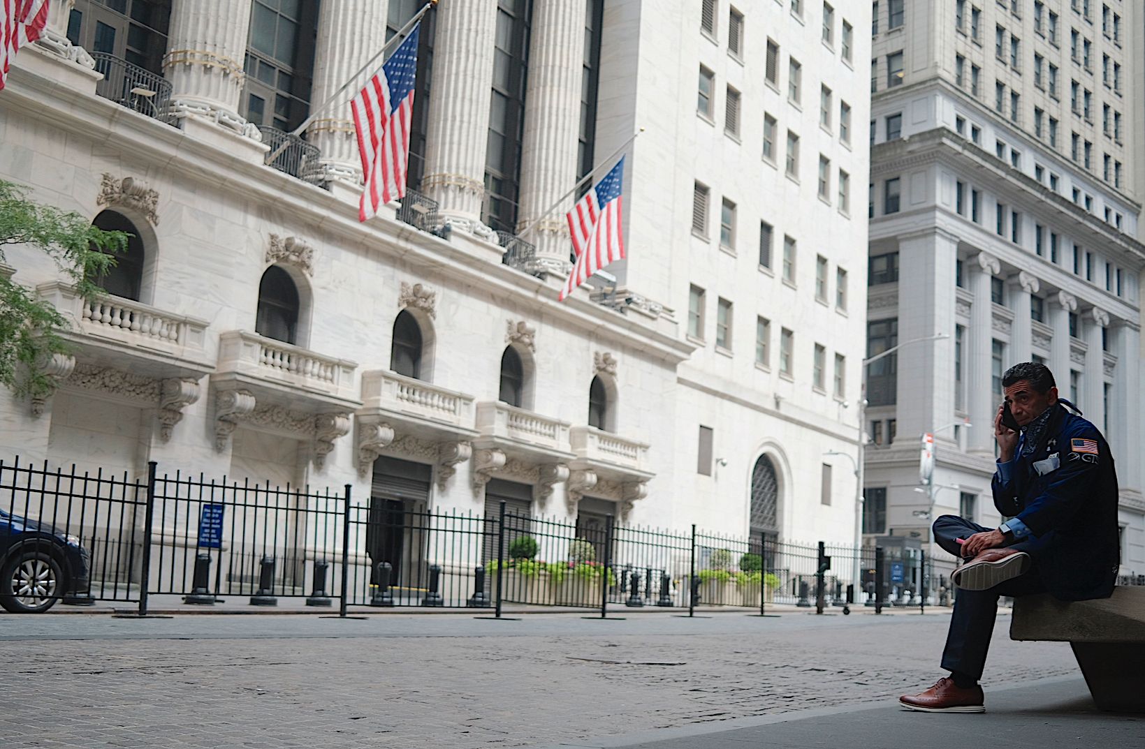 Seorang pedagang saham sedang menelpon di depan gedung saham New York Wall Street, Amerika Serikat.