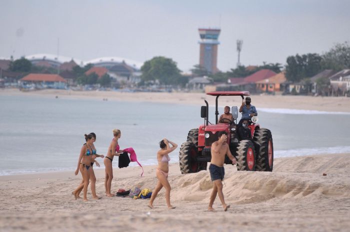 Petugas dengan traktor meminta wisatawan untuk meninggalkan Pantai Kedonganan, Badung, Bali, karena wabah Covid-19.  
