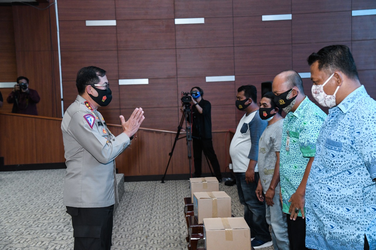 Kakorlantas Polri Irjen Pol Istiono (kiri) memberikan bantuan masker dan sembako kepada perwakilan penerima manfaat.