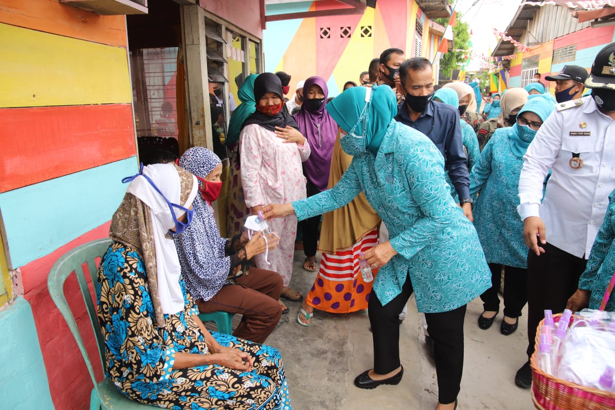 Ketua Umum TP PKK Tri Tito Karnavian (kanan) membagikan masker kepada masyarakat di Jambi pada Rabu (26/8).