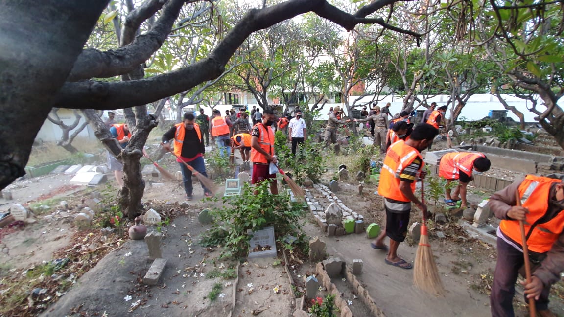 Para pelanggar protokol kesehatan yang dihukum membersihkan makan. 