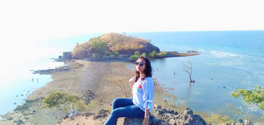 Seorang warga berswafoto dengan latar belakang Pulau Nusa Kutu.