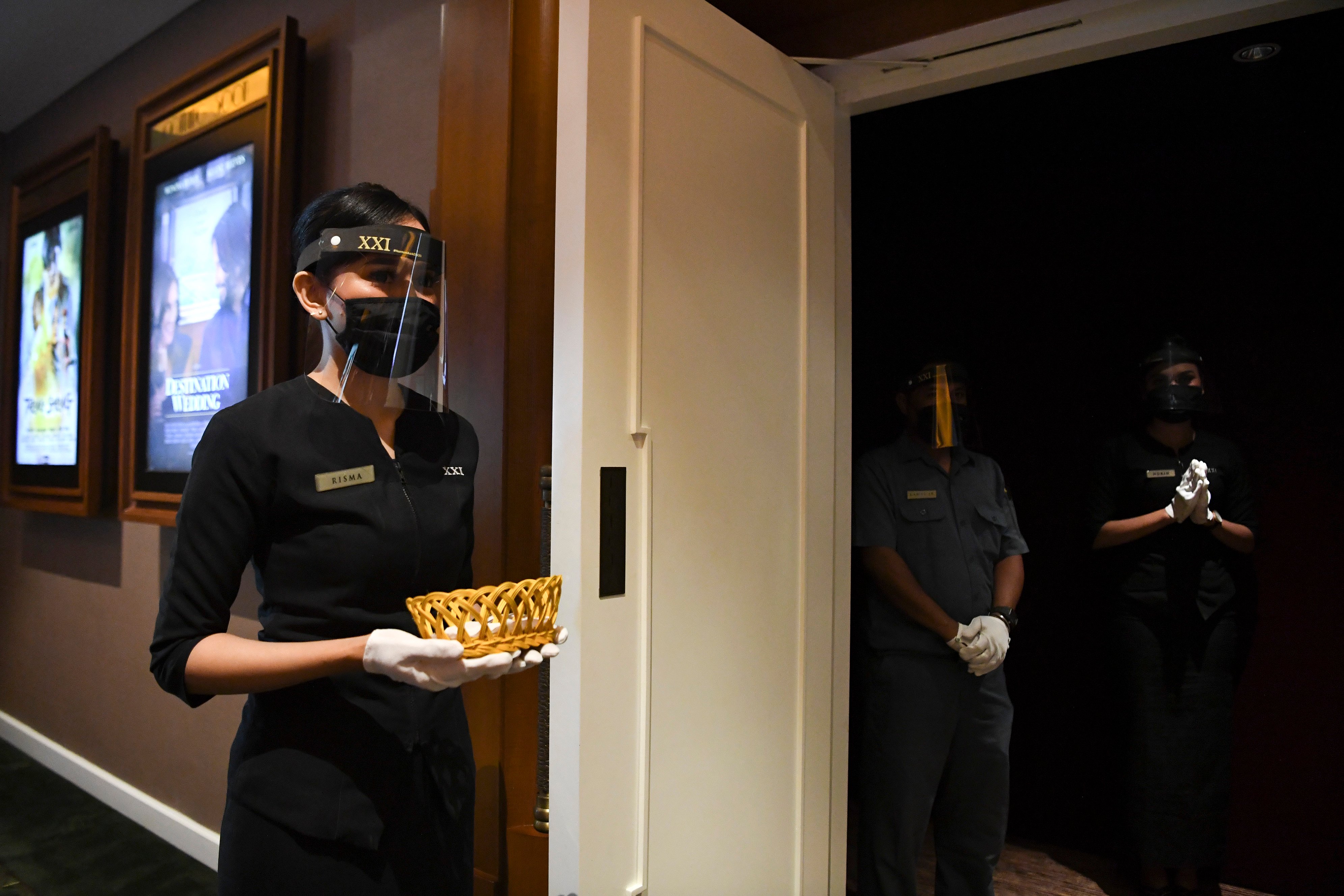 Pekerja bioskop menggunakan alat pelindung wajah dan masker saat dilaksanakan pemeriksaan kesiapan bioskop beroperasi kembali di Jakarta.