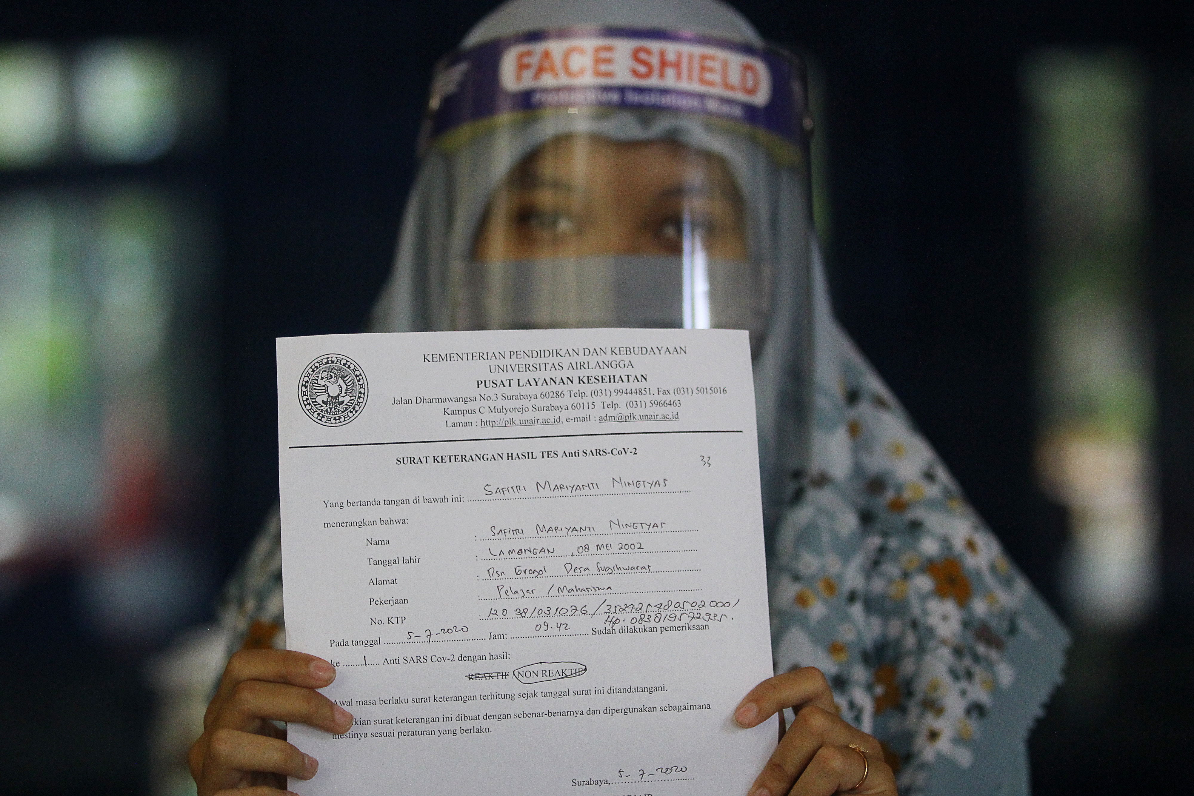 Peserta memperlihatkan surat keterangan hasil tes cepat sebelum mengikuti Ujian Tulis Berbasis Komputer di Surabaya, Minggu (5/7).