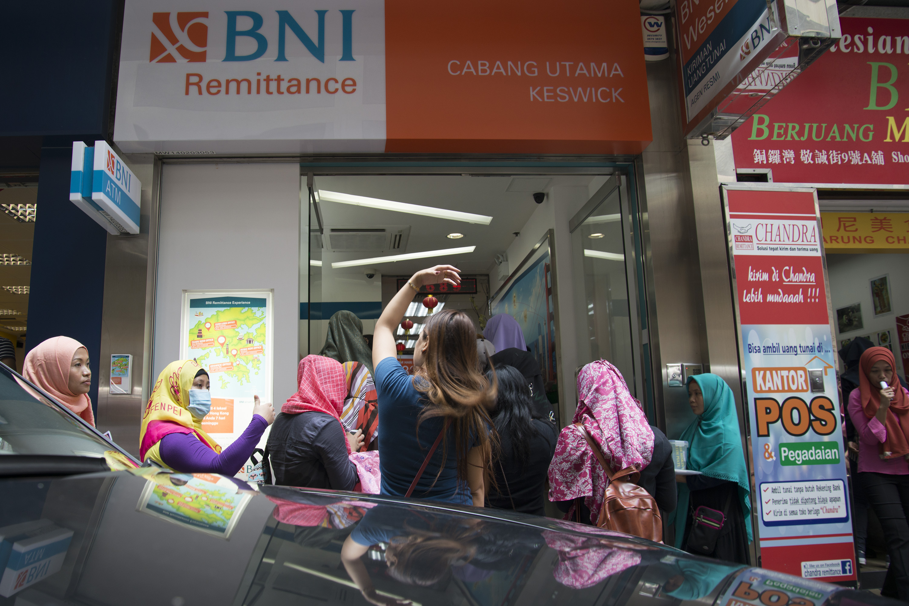  Para buruh migran Indonesia (BMI) yang bekerja di Hongkong mengantre di Bank BNI cabang Keswick, Hong Kong, Minggu (21/8