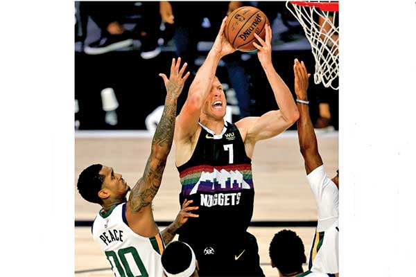  Pemain Denver Nuggets Mason Plumlee (tengah) berusaha menjaringkan bola setelah menerobos hadangan dua peman Utah Jazz 