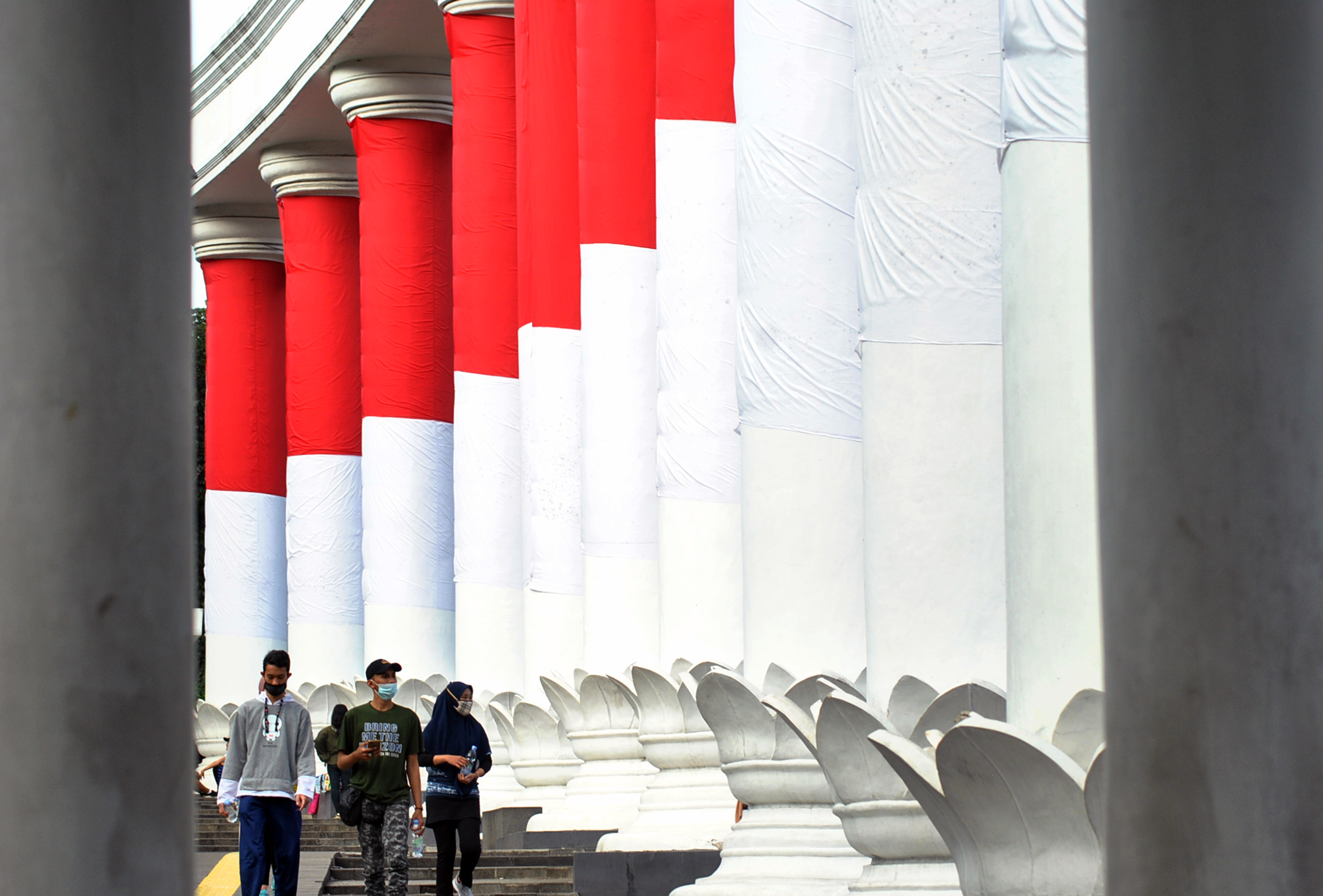 Warga dengan menggunakan masker berjalan di Tepas Lawang Salapan, Kota Bogor, Jawa Barat