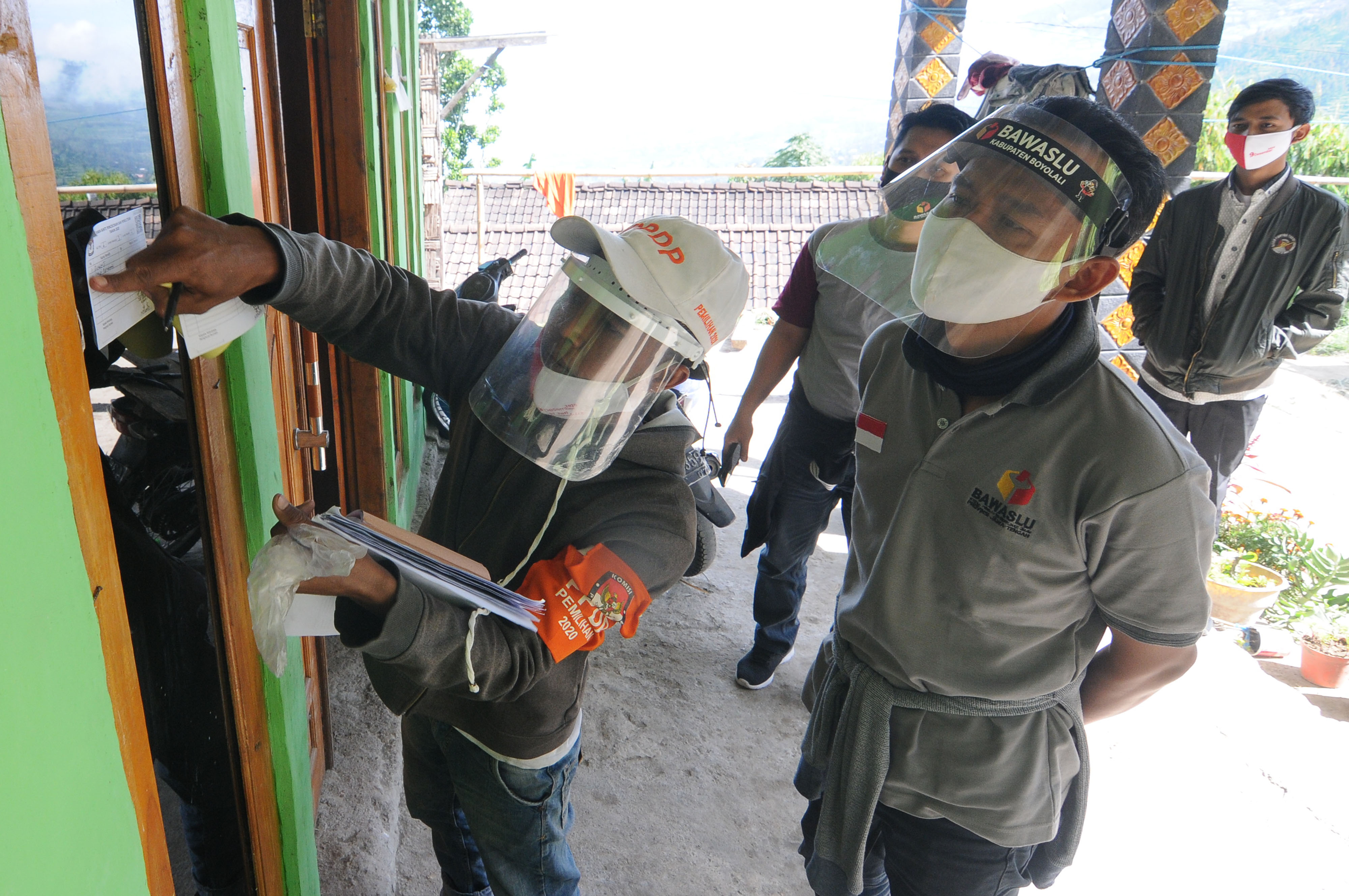 Petugas Bawaslu Jawa Tengah (kanan) mengawasi petugas PPDP saat menempelkan stiker bukti coklit data pemilih Pikada Serentak 2020.