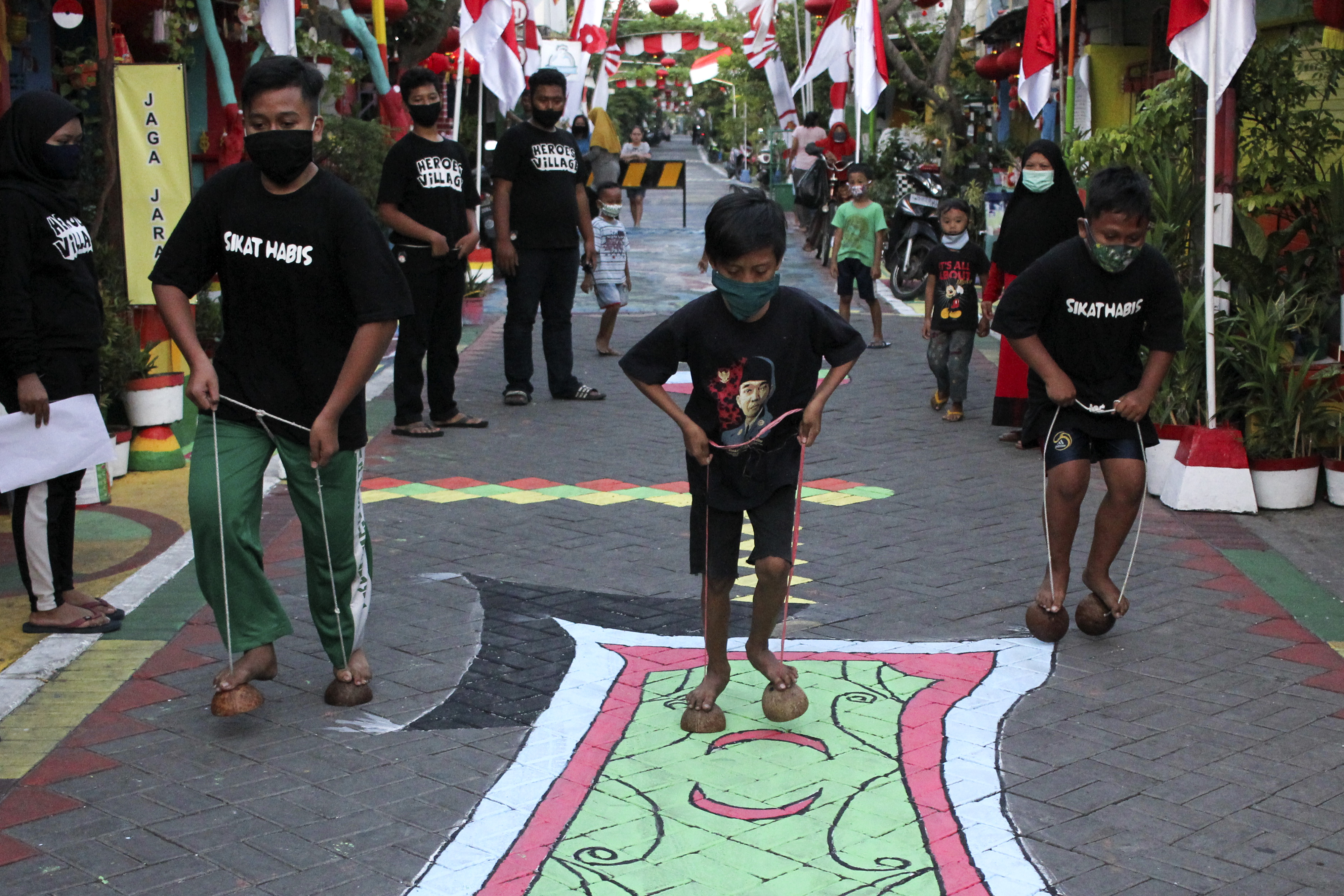  Warga mengikuti lomba 'Egrang Tempurung Kelapa' di kawasan Mulyorejo Selatan, Surabaya, Jawa Timur, Minggu (9/8/2020). 