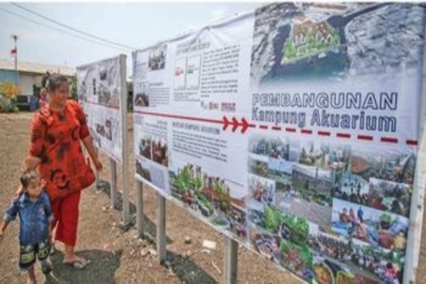Warga melihat rencana pembangunan di Kampung Akuarium, Jakarta, Rabu (19/8).
