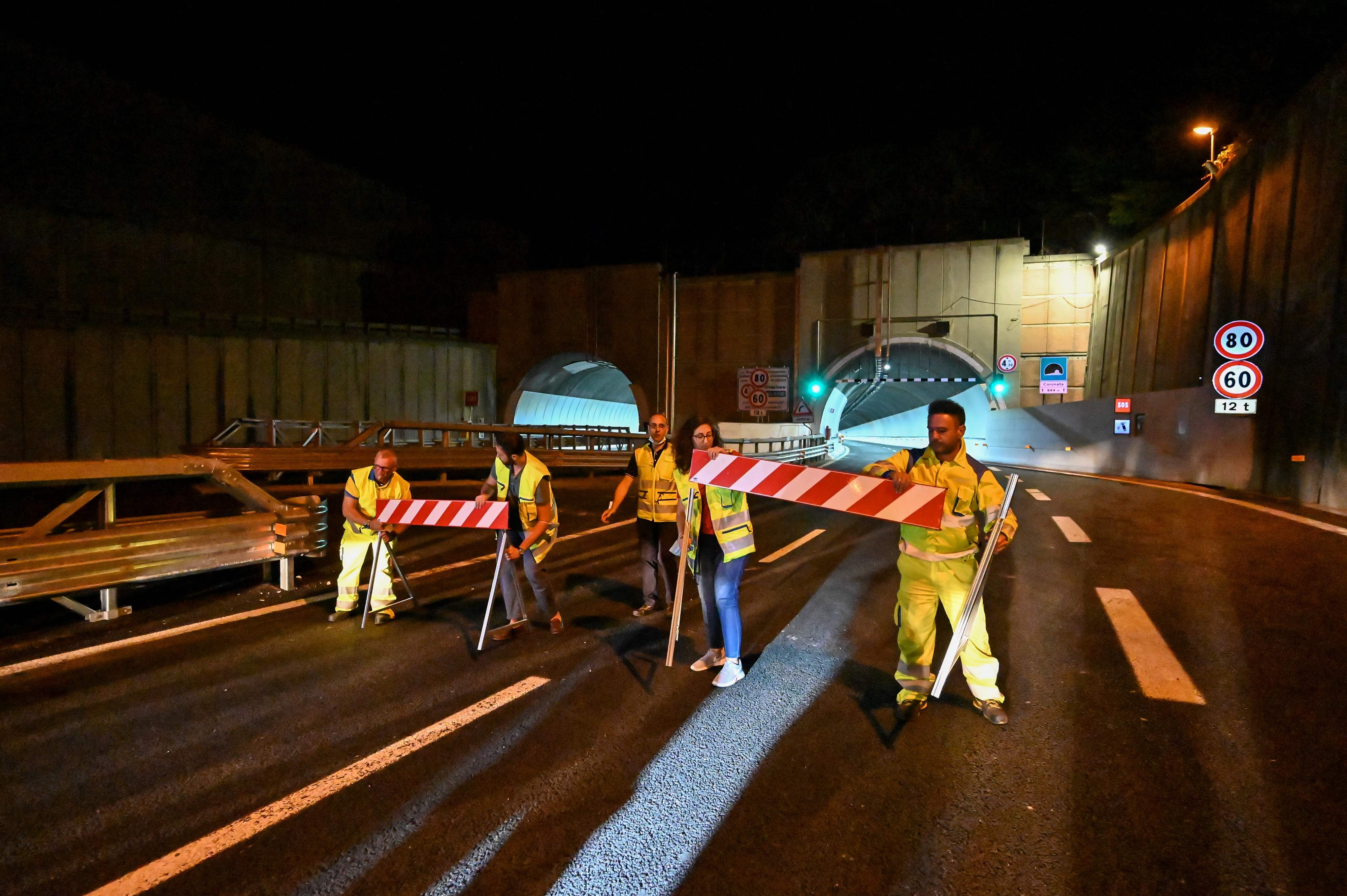 Petuga menyingkirkan barier agar mobil pertama bisa melintas di Jalan Layang San Giorgio di Genoa setelah diresmikan.