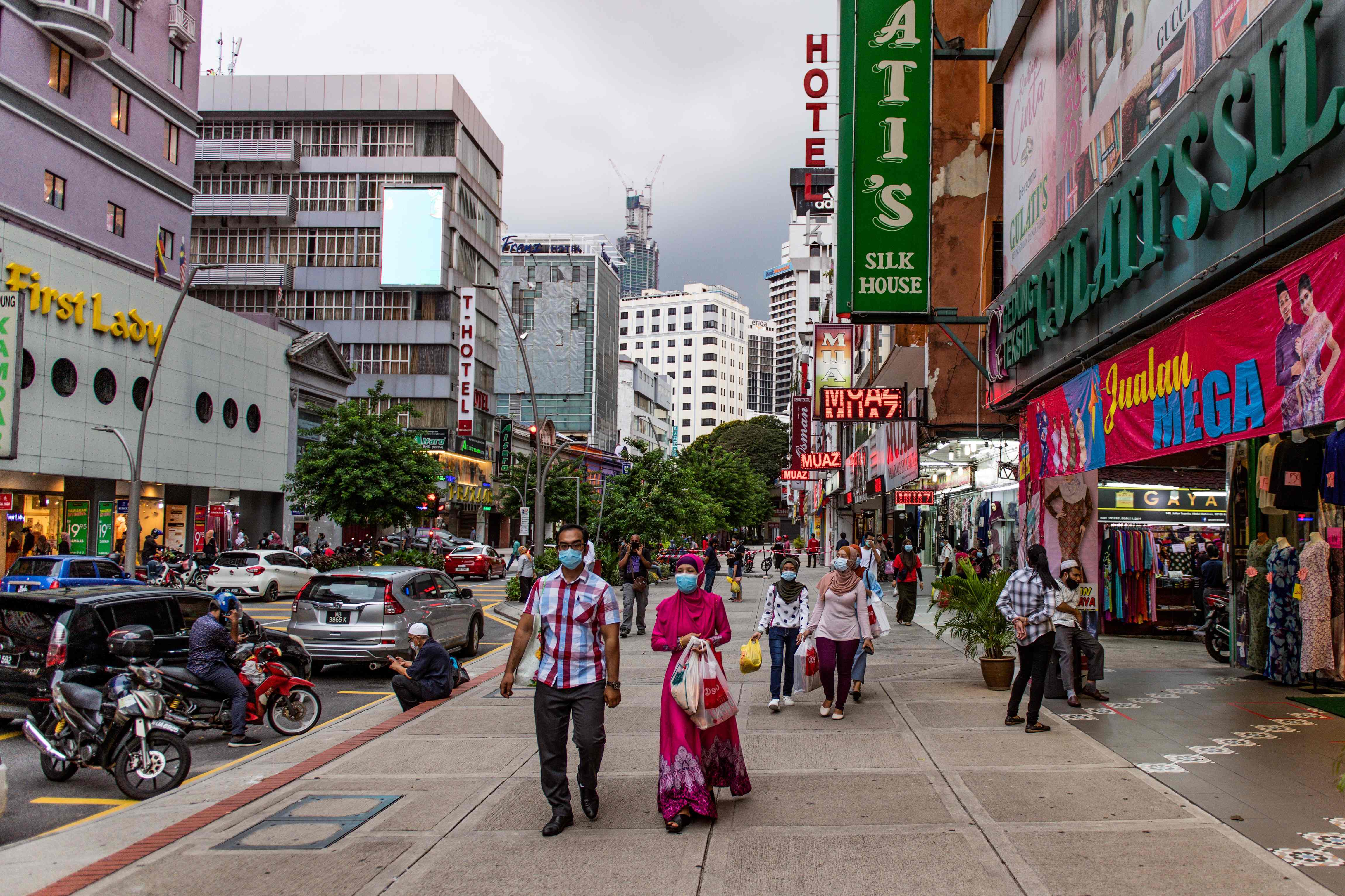 Warga menggunakan masker berjalan di kawasan perbelanjaan Kuala Lumpur, malasysia