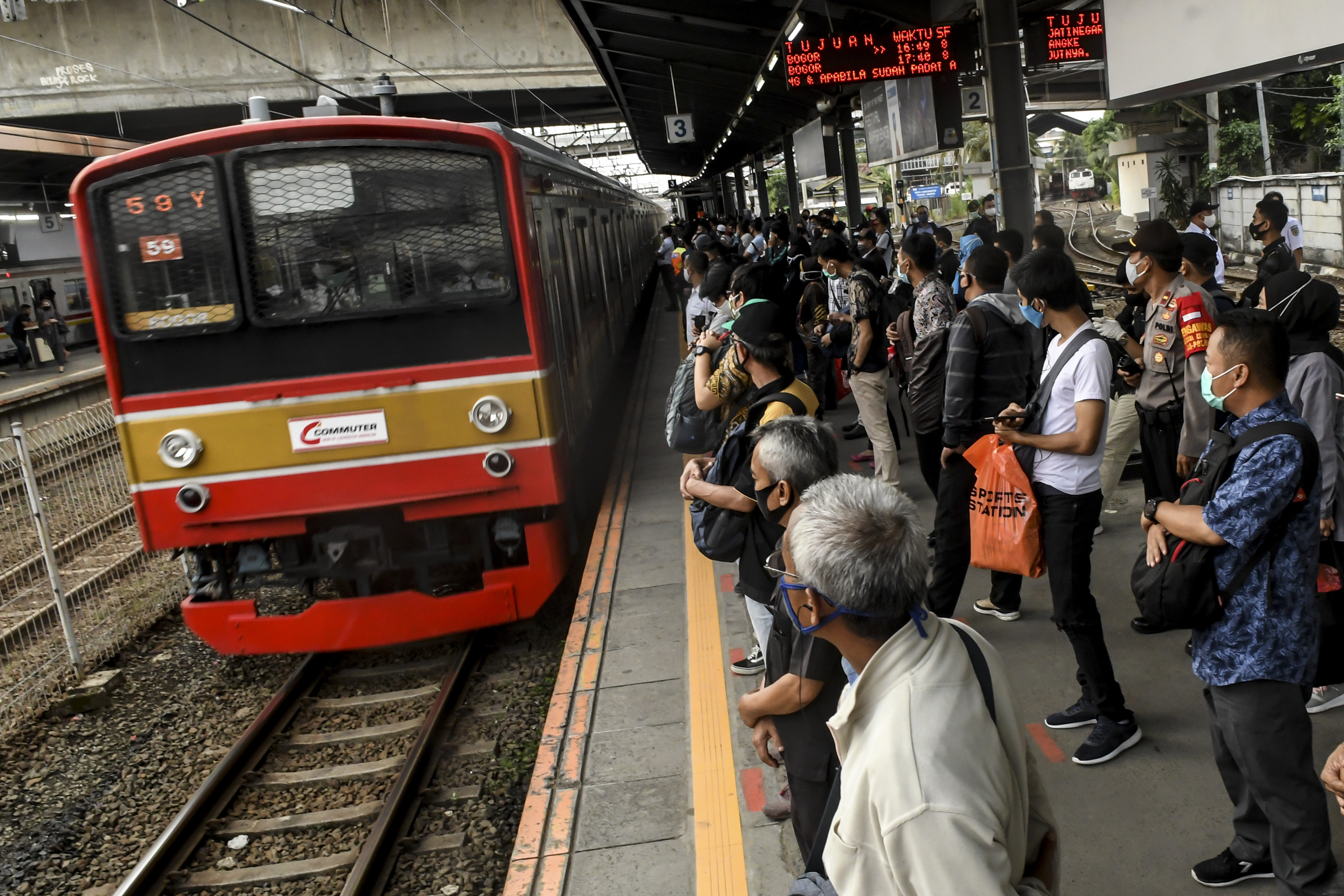 Penumpang KRL commuter line menunggu kereta di Stasiun Tanah Abang, Jakarta.