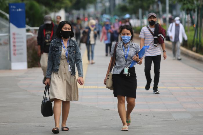 Pekerja melewati trotoar selepas jam kantor di kawasan Sudirman, Jakarta, Selasa (21/4).  