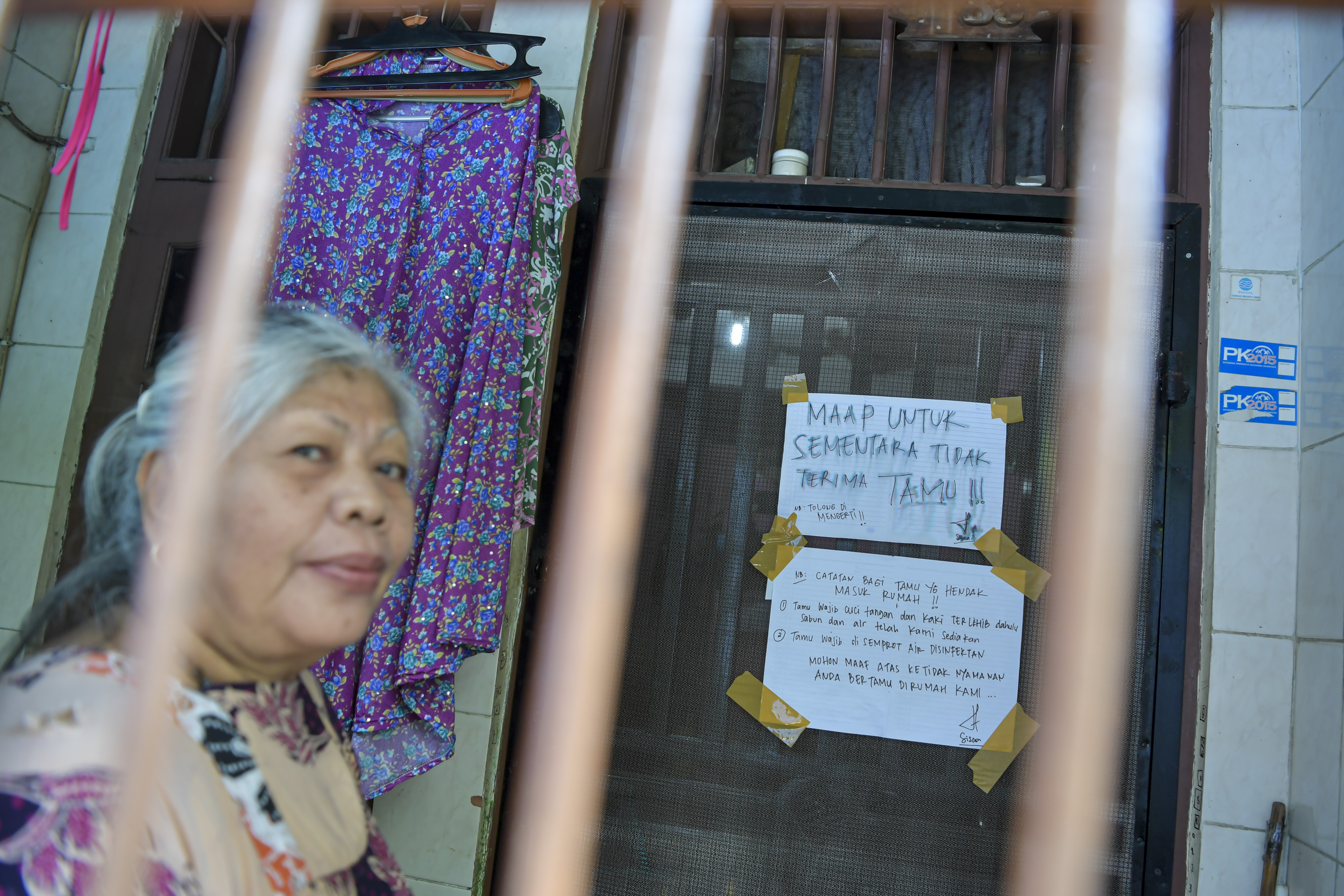 Warga berada di teras rumahnya di kawasan Tambora, Jakarta, Jumat (3/4/2020).